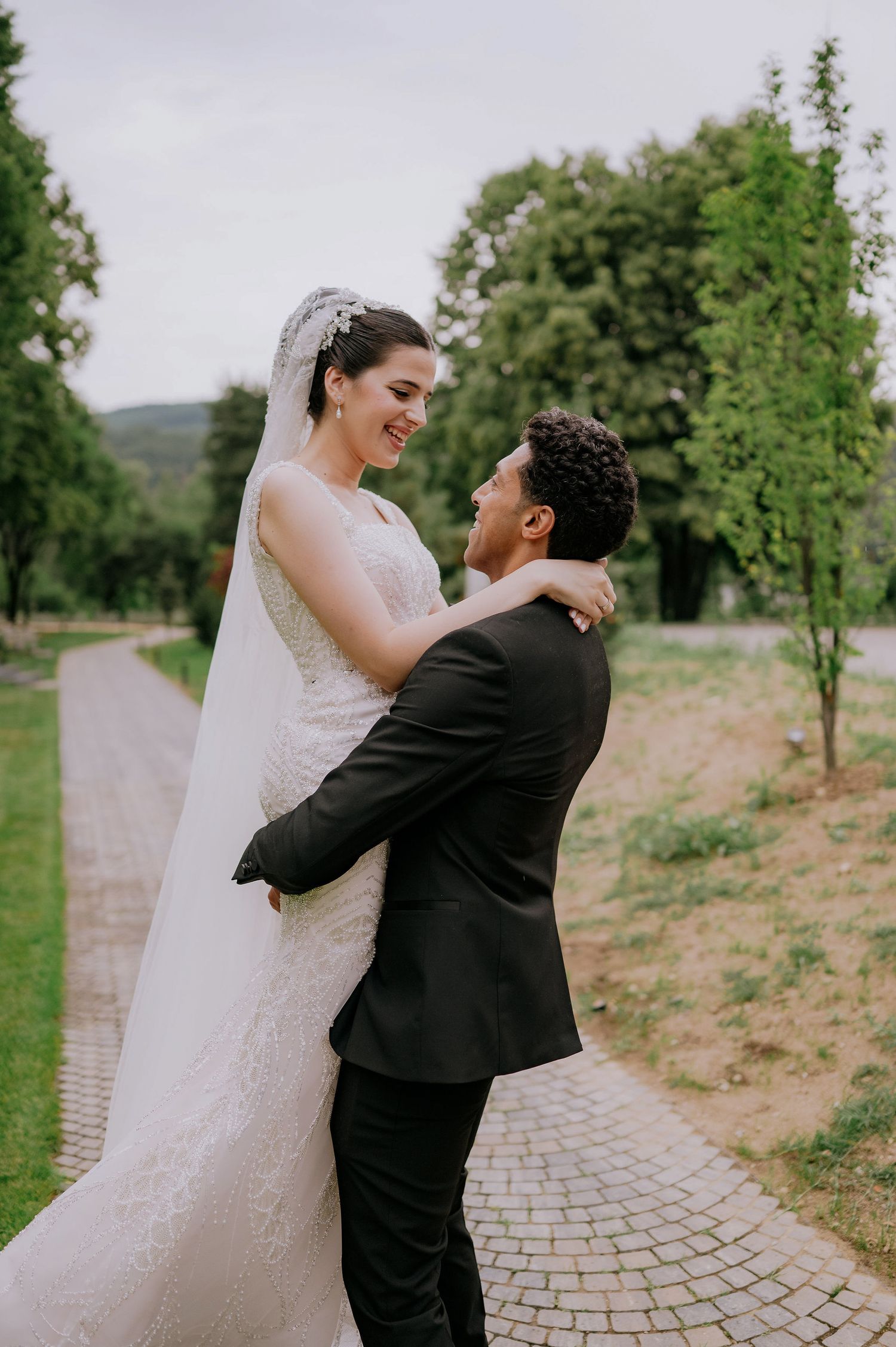 Romantic wedding photo series capturing joyful moments between newlyweds on a stone path outdoors.