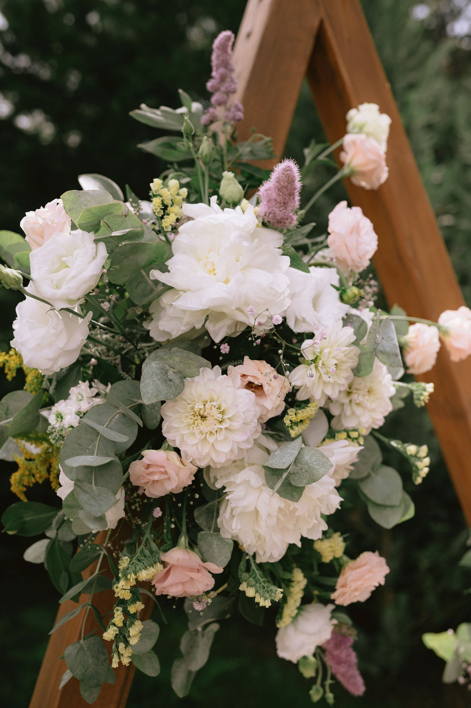 Wedding arch decorated with lush white and pink floral arrangements.