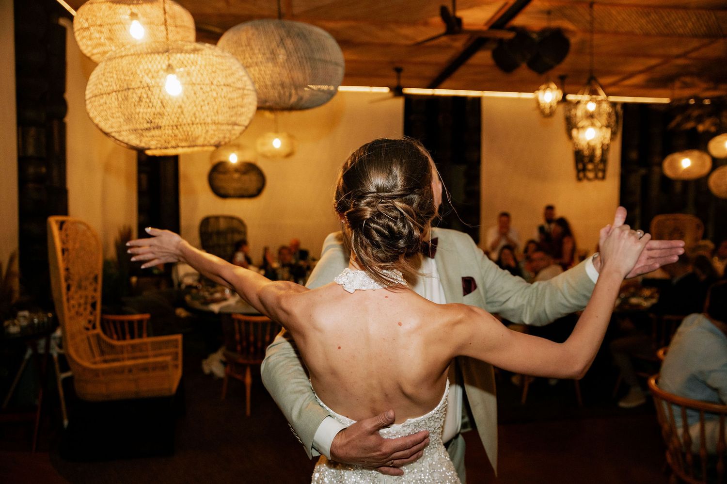 Couples dancing intimately at a wedding reception with warm ambient lighting.