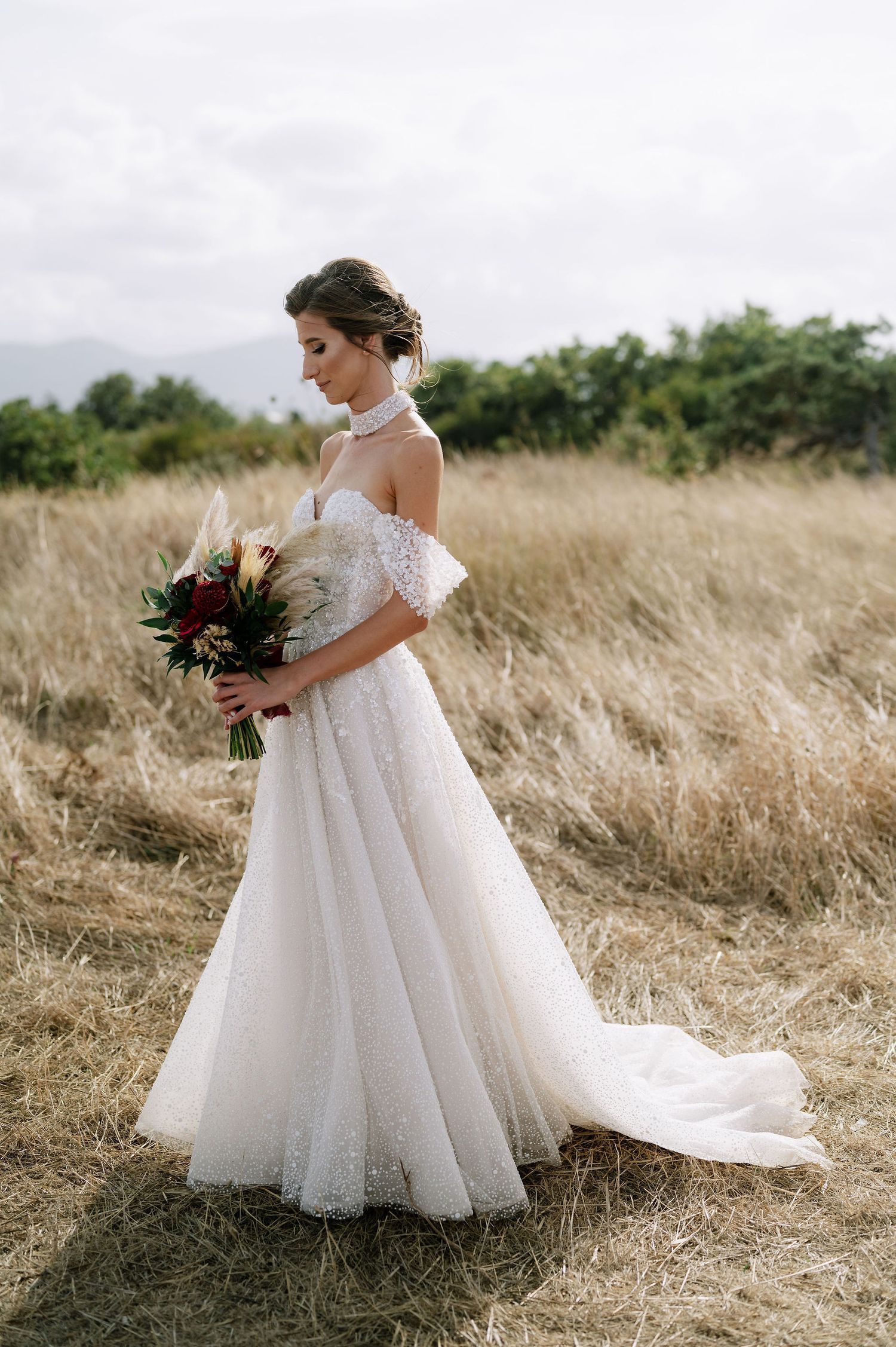 An elegant bridal portrait showing the detailed lace bodice and full tulle skirt of a wedding gown.