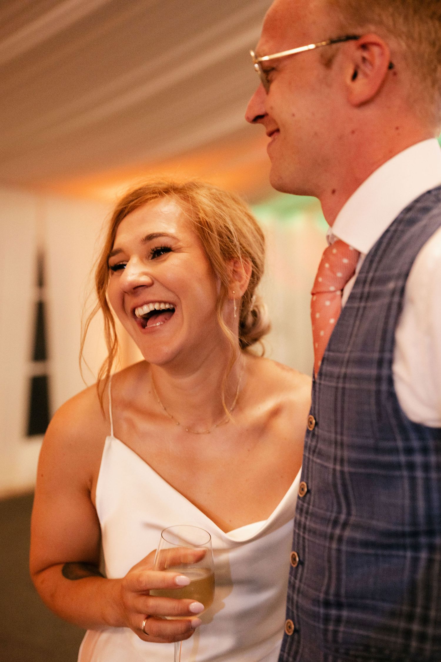 A joyful moment captured during a wedding reception with laughter and celebration.