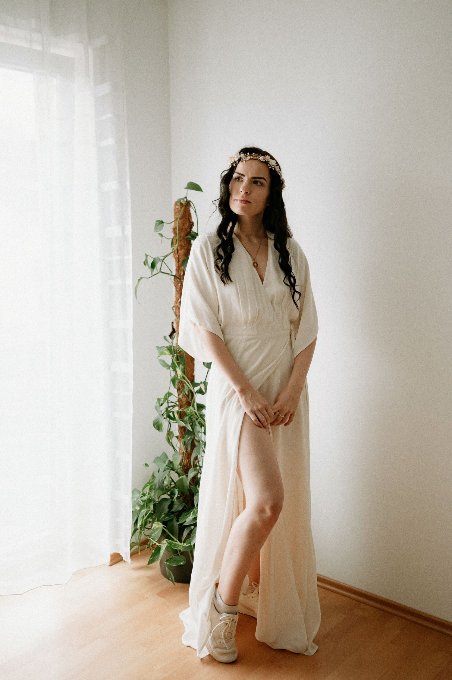 Artistic indoor portrait with soft natural lighting and minimalist white interior design.