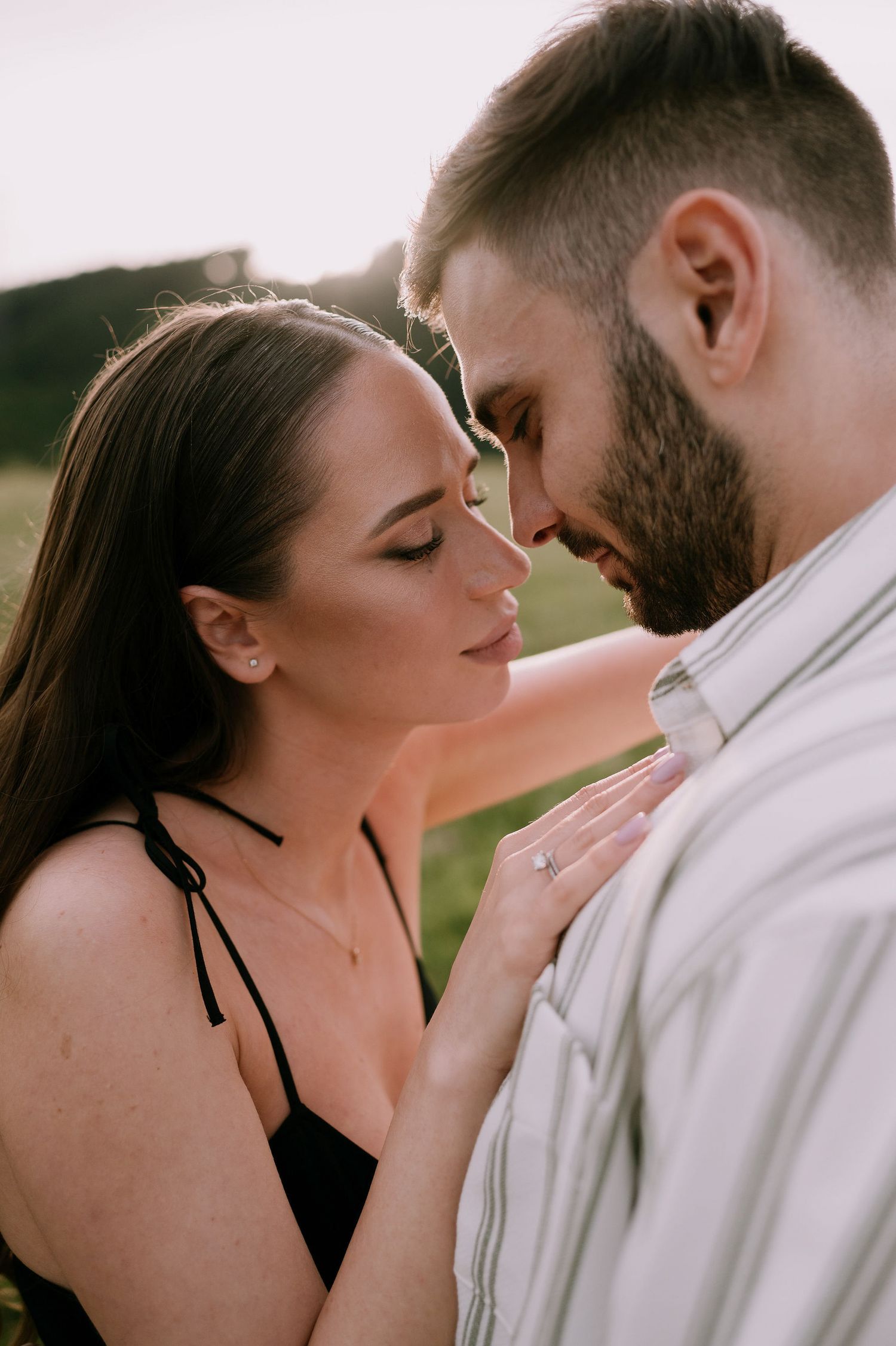 A romantic couple in white clothing share intimate moments in a series of tender outdoor portrait photographs.