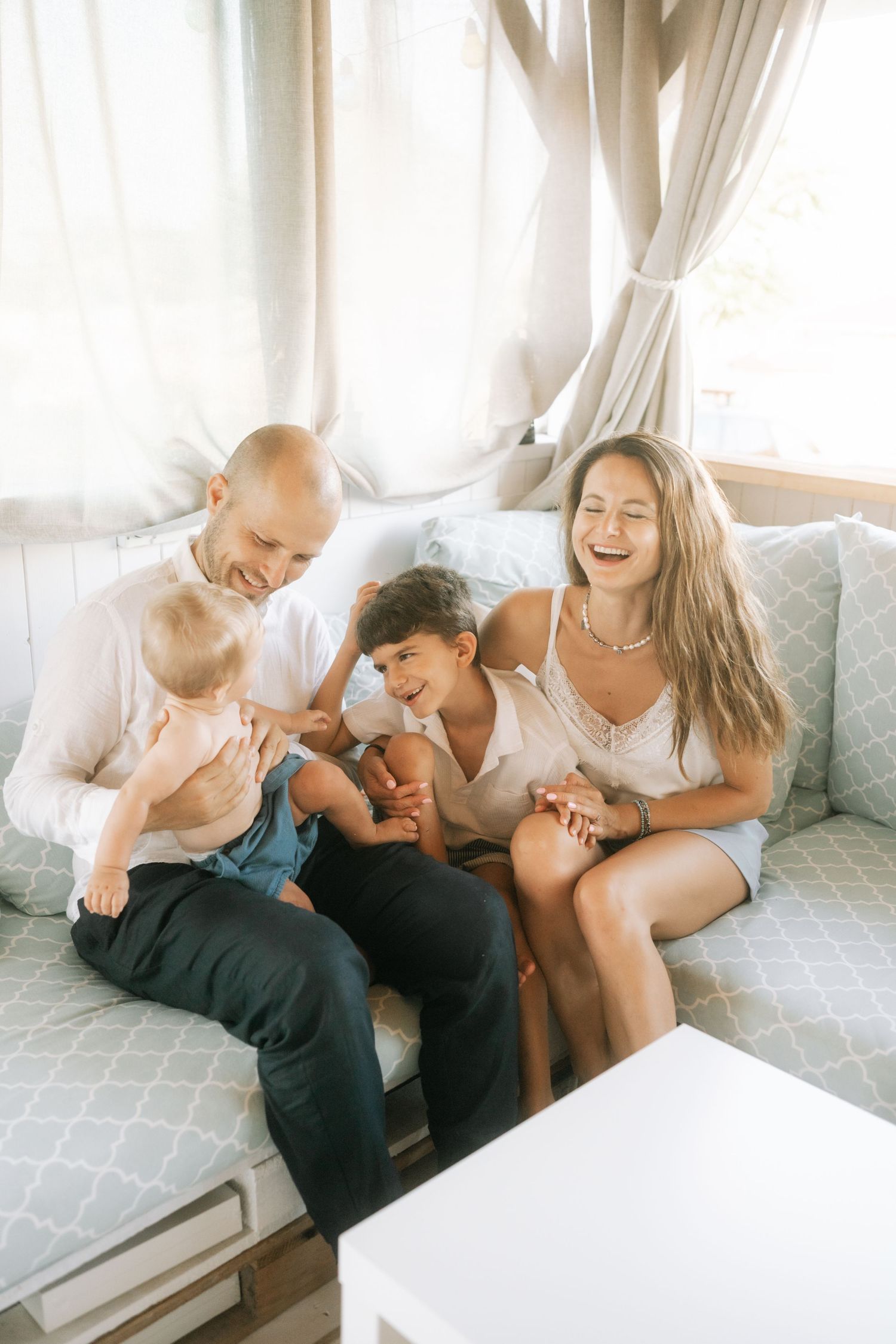 A candid moment of laughter and connection between family members relaxing together on a couch.