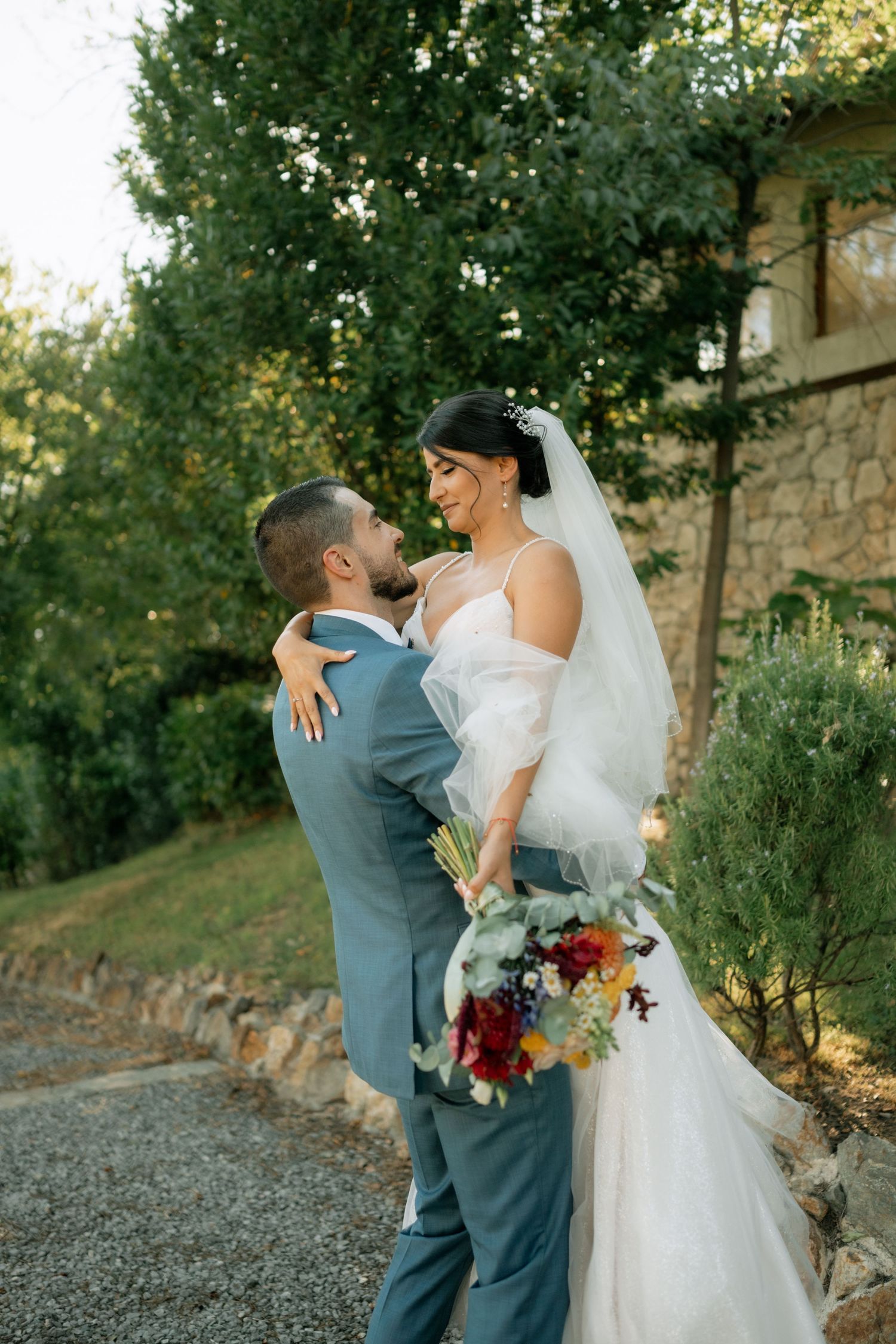 A couple shares an intimate moment in a garden setting during their wedding photoshoot.