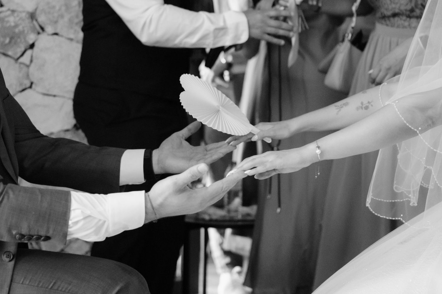 A bride and groom cut their elegant white wedding cake together during their reception celebration.