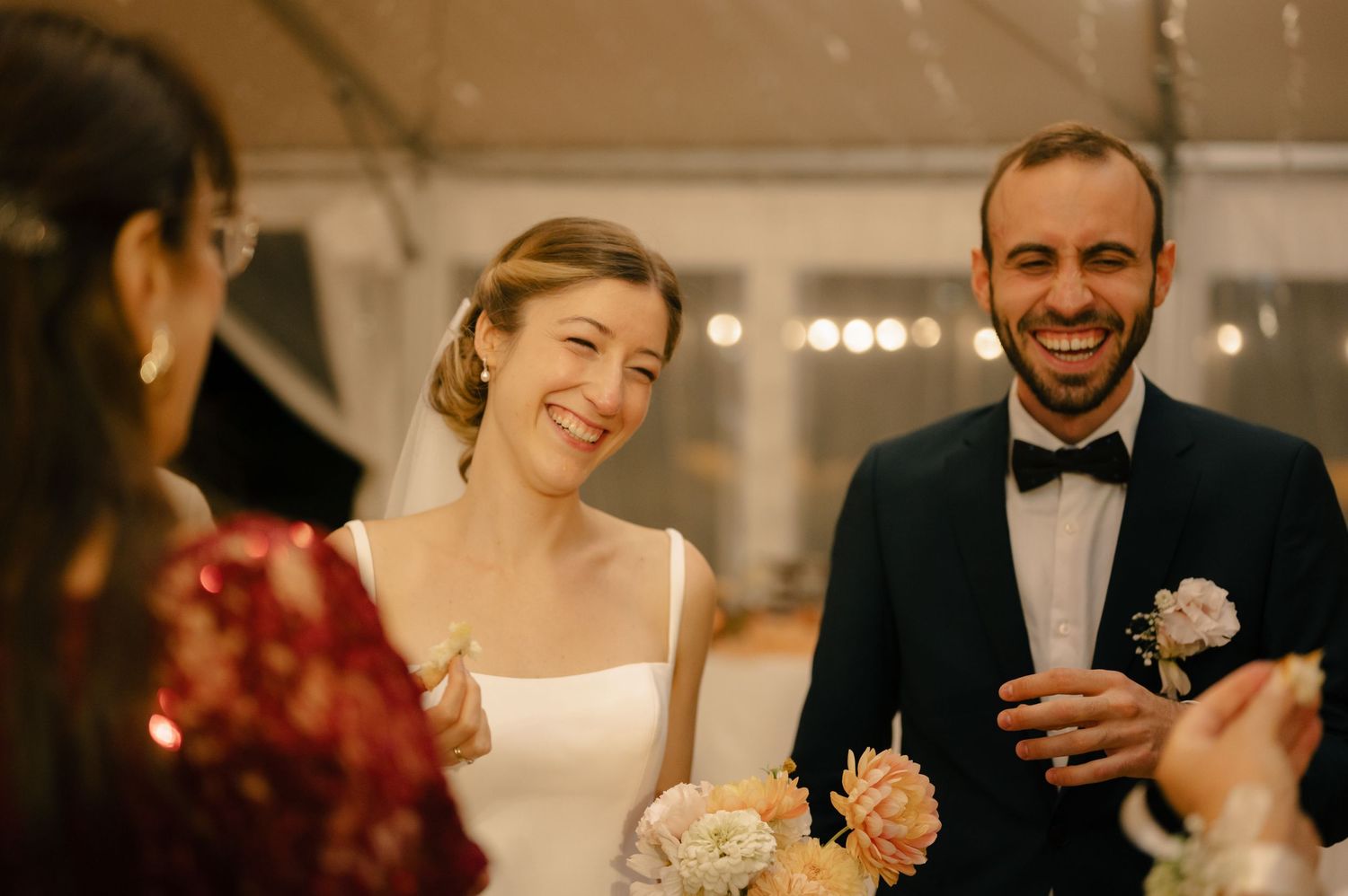 Wedding reception guests sharing joyful conversations at elegantly decorated tables under soft lighting.
