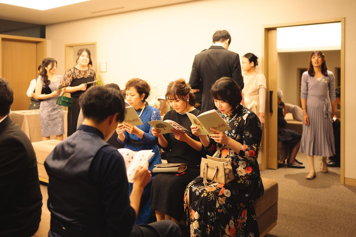 Guests gather in a warmly lit reception area with wooden interior details.