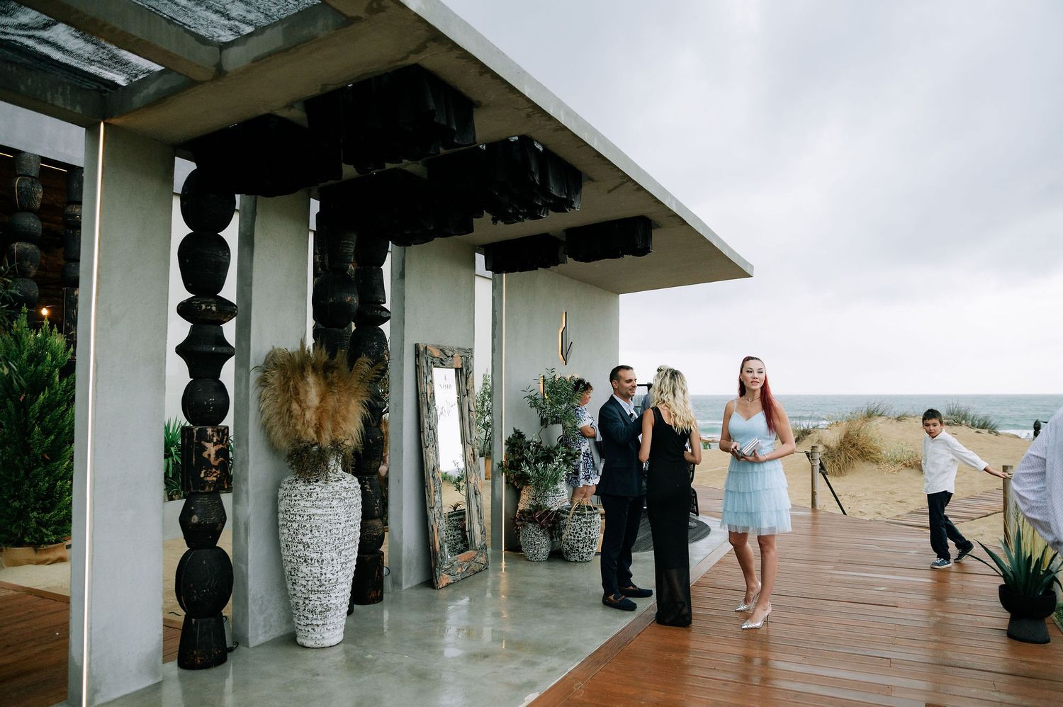 Modern white venue space with tall pillars and guests mingling.
