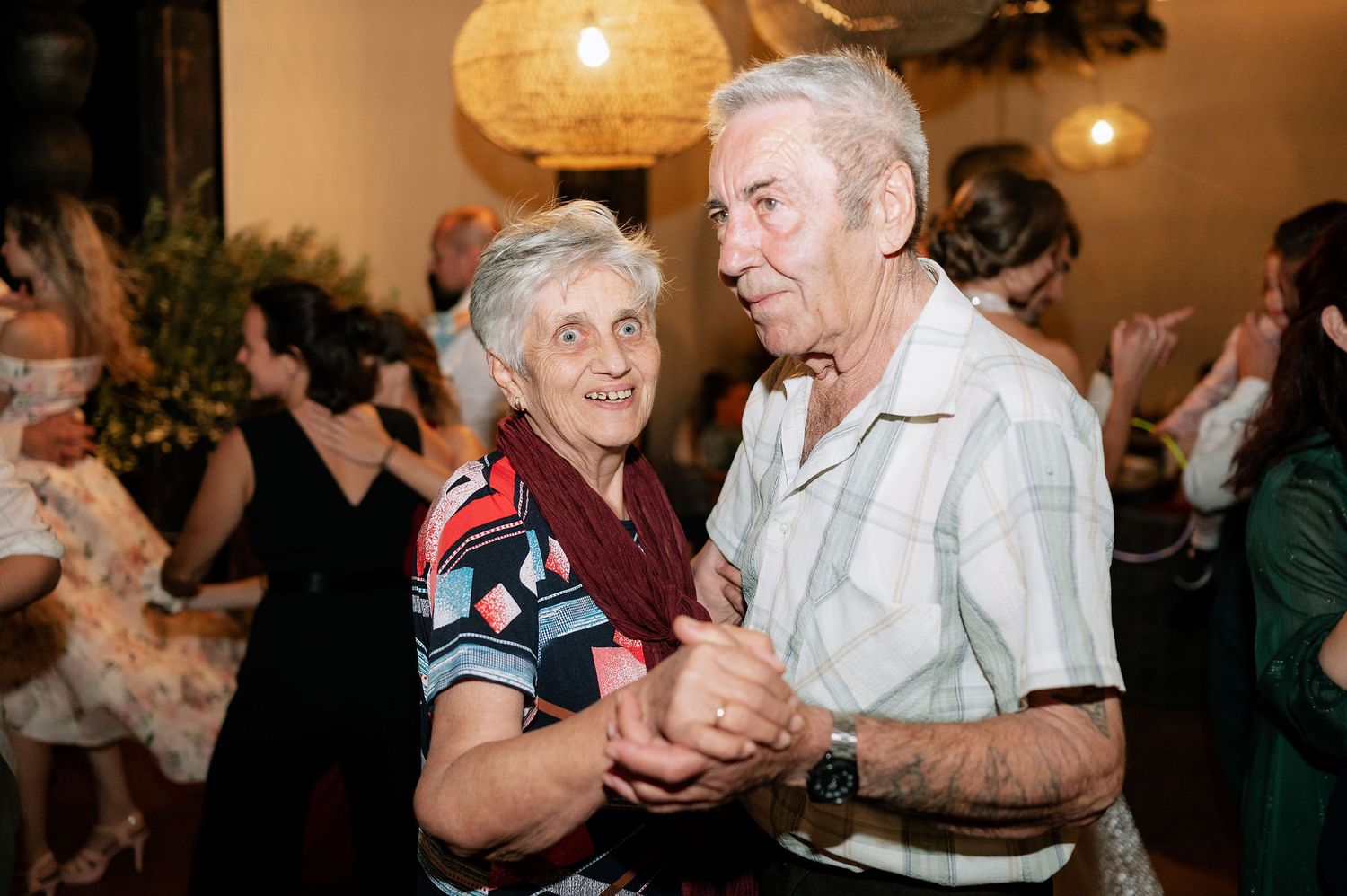 Wedding reception dance floor filled with joyful guests enjoying the celebration.