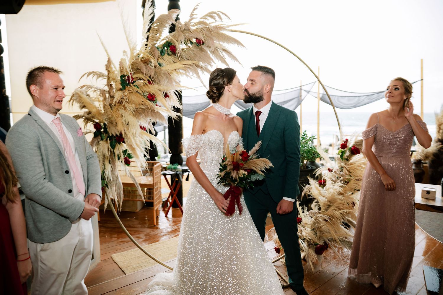 Wedding party gathered in a modern venue decorated with pampas grass and natural elements.
