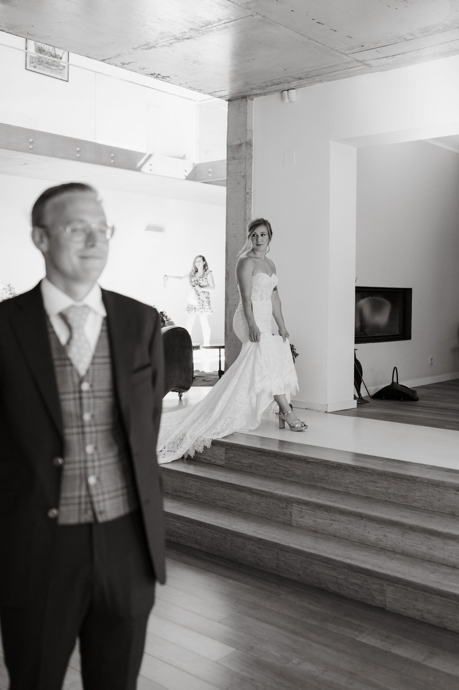 Black and white photo of a large room with tiered flooring and formal wear.
