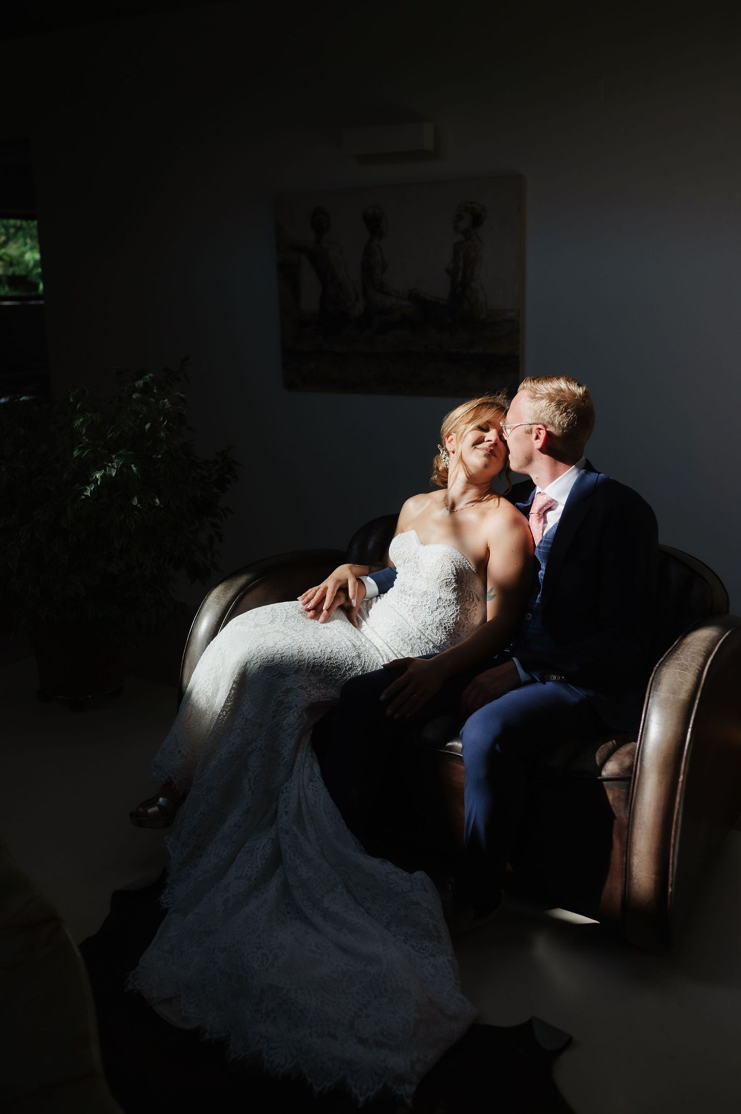 Dramatic low-light wedding portrait with couple in intimate embrace.