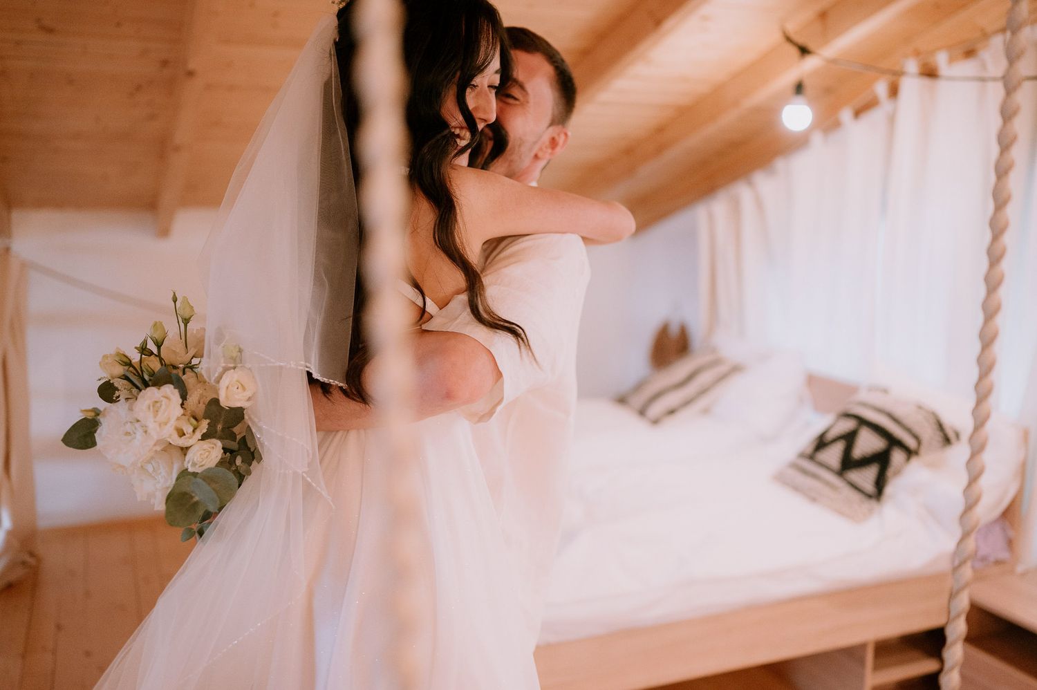 Intimate wedding photography featuring white dress against wooden architecture.