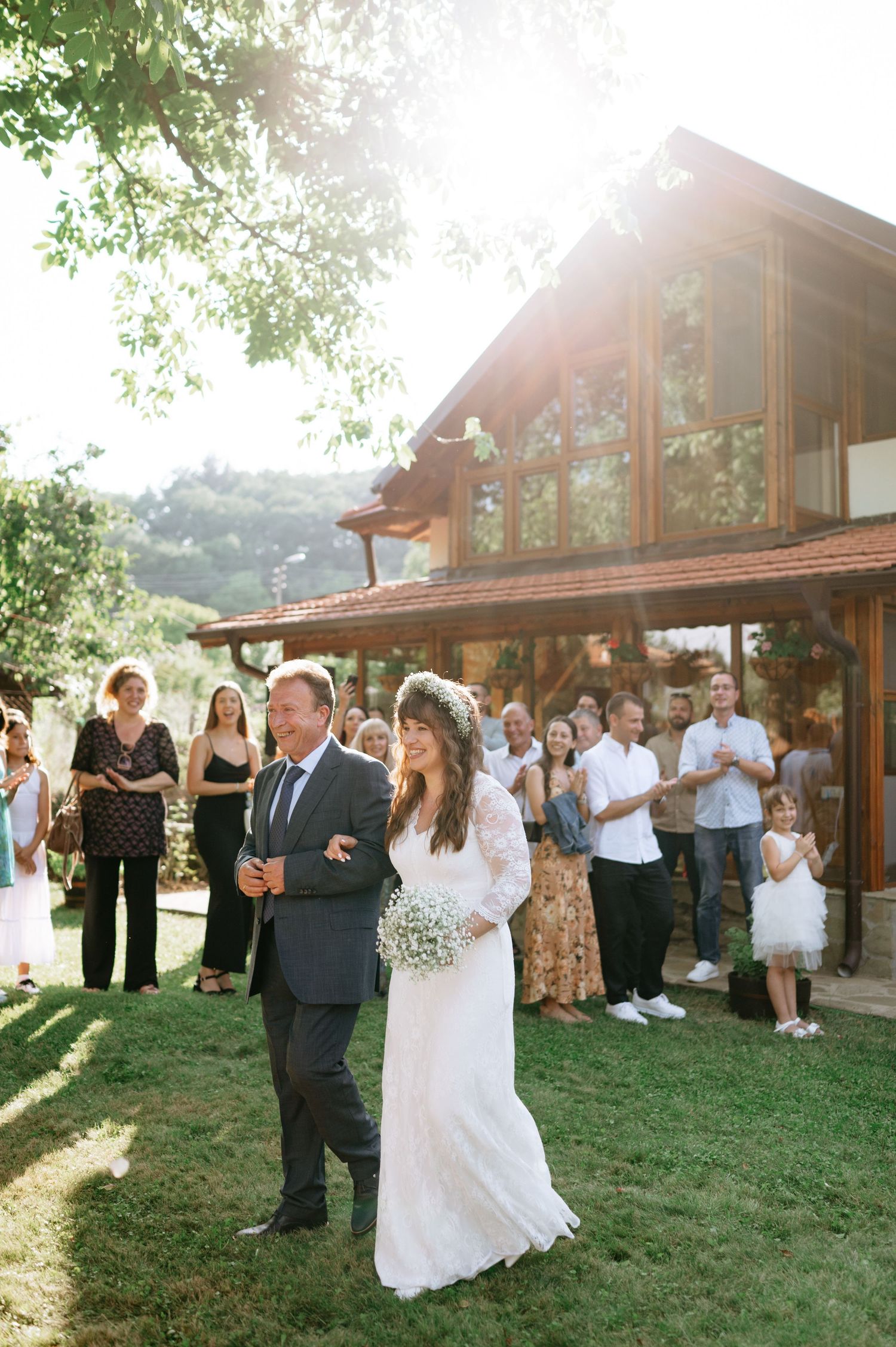 Wedding celebration outside a rustic wooden lodge with guests watching a couple dance.
