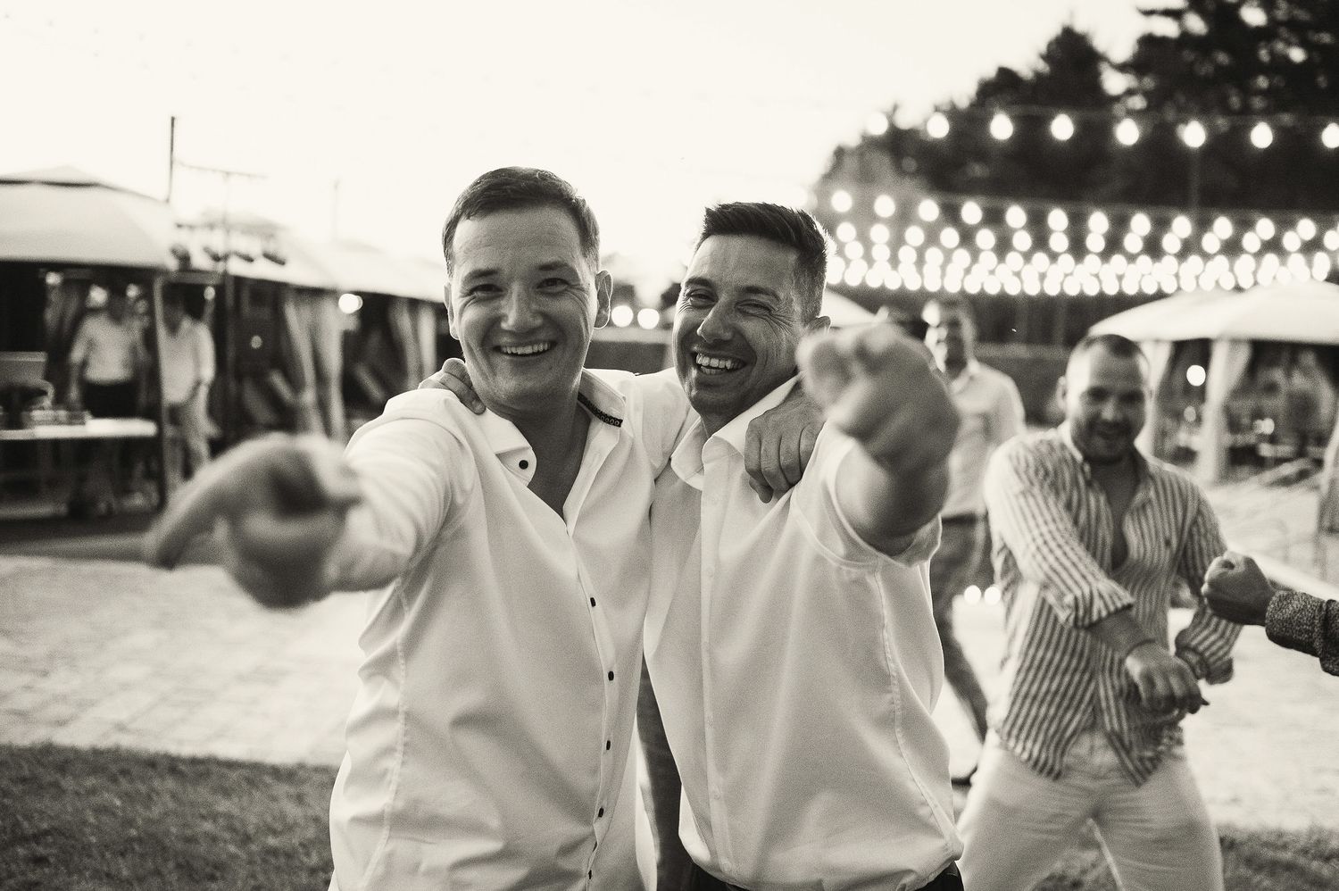 Group of friends laughing and celebrating at an outdoor summer party.