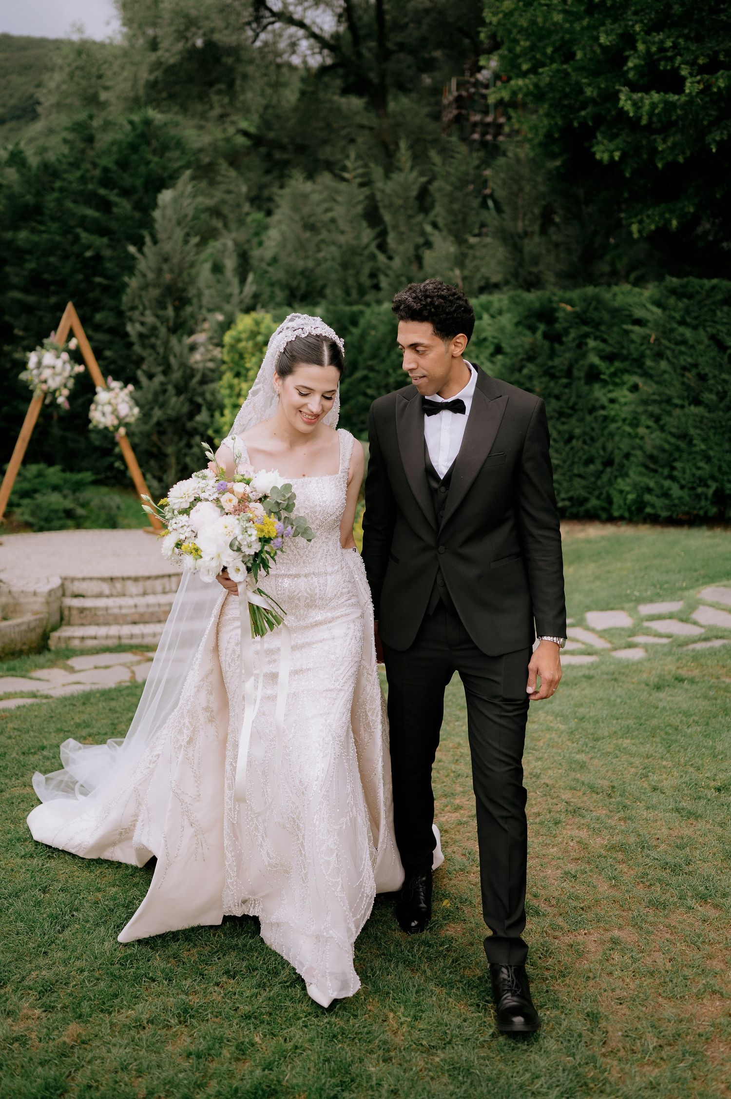 Couple walking hand in hand during outdoor wedding photoshoot.