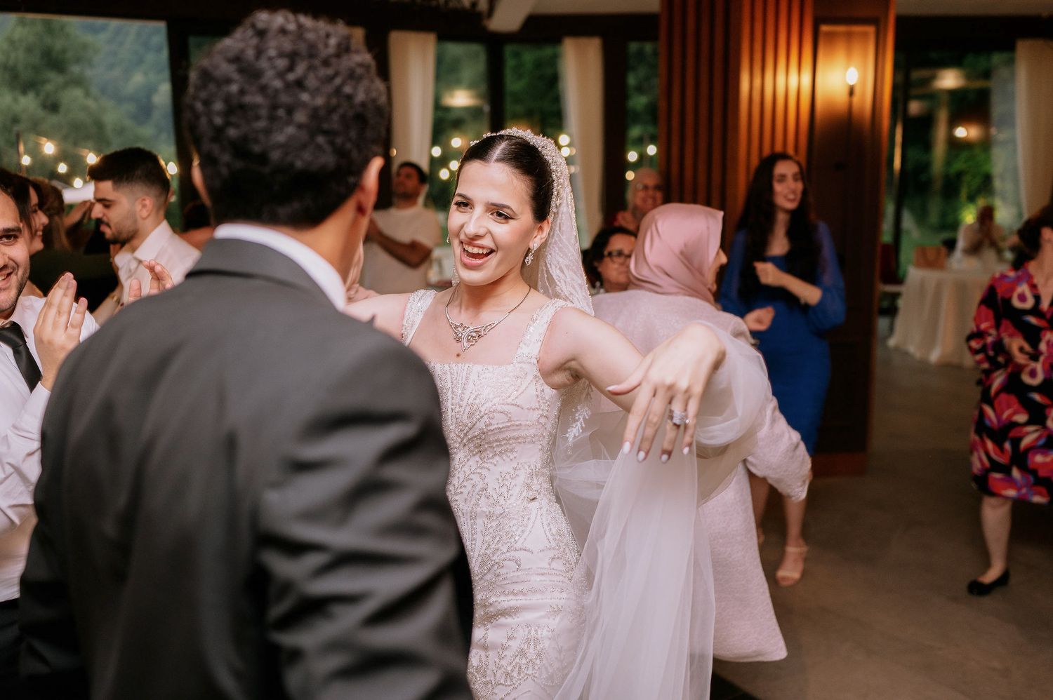 Joyful wedding reception scene with guests dancing and celebrating.