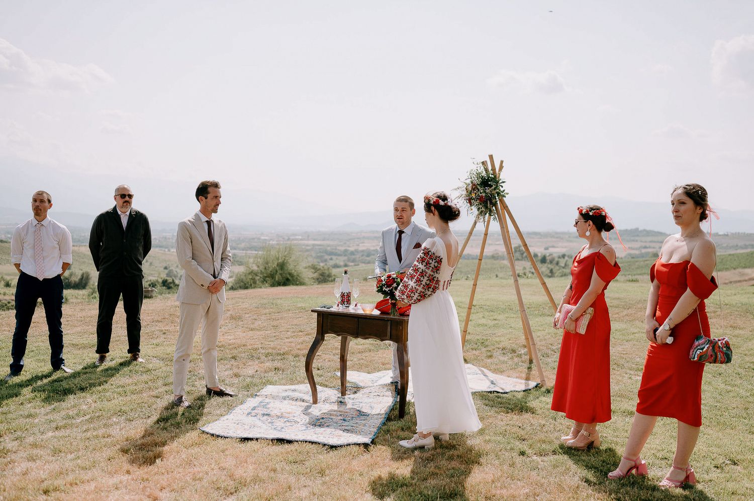 Wedding party and guests gathered on hilltop for intimate outdoor ceremony.