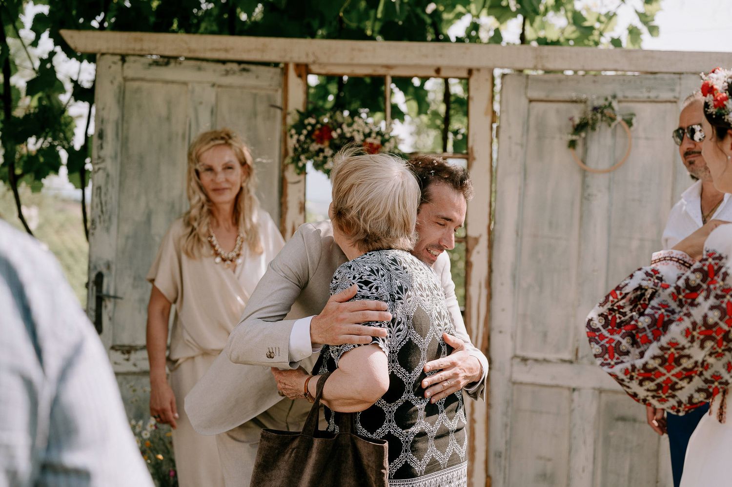 A tender moment captured at a rustic wedding venue with vintage doors as backdrop.