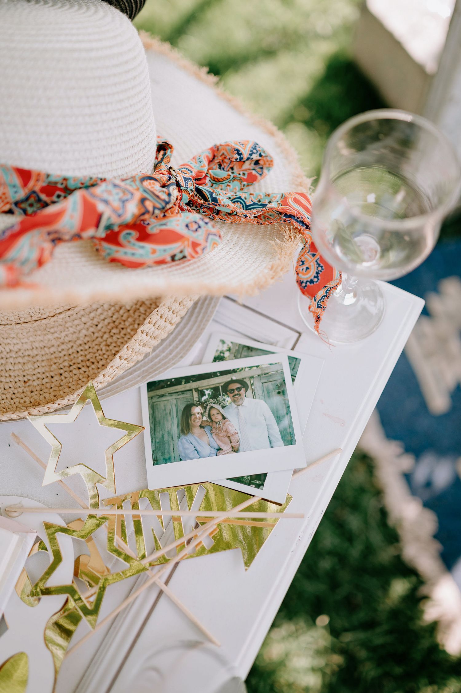 Wedding guestbook setup with scattered photos and decorative elements on a light colored surface.
