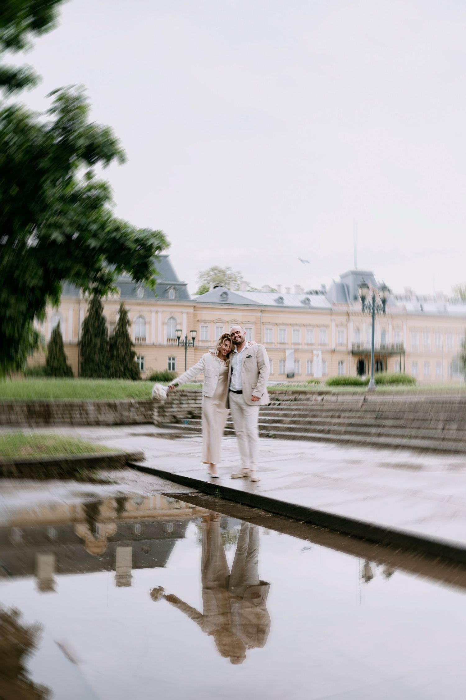 A dreamy scene with reflections in water near stone steps at a classical building.