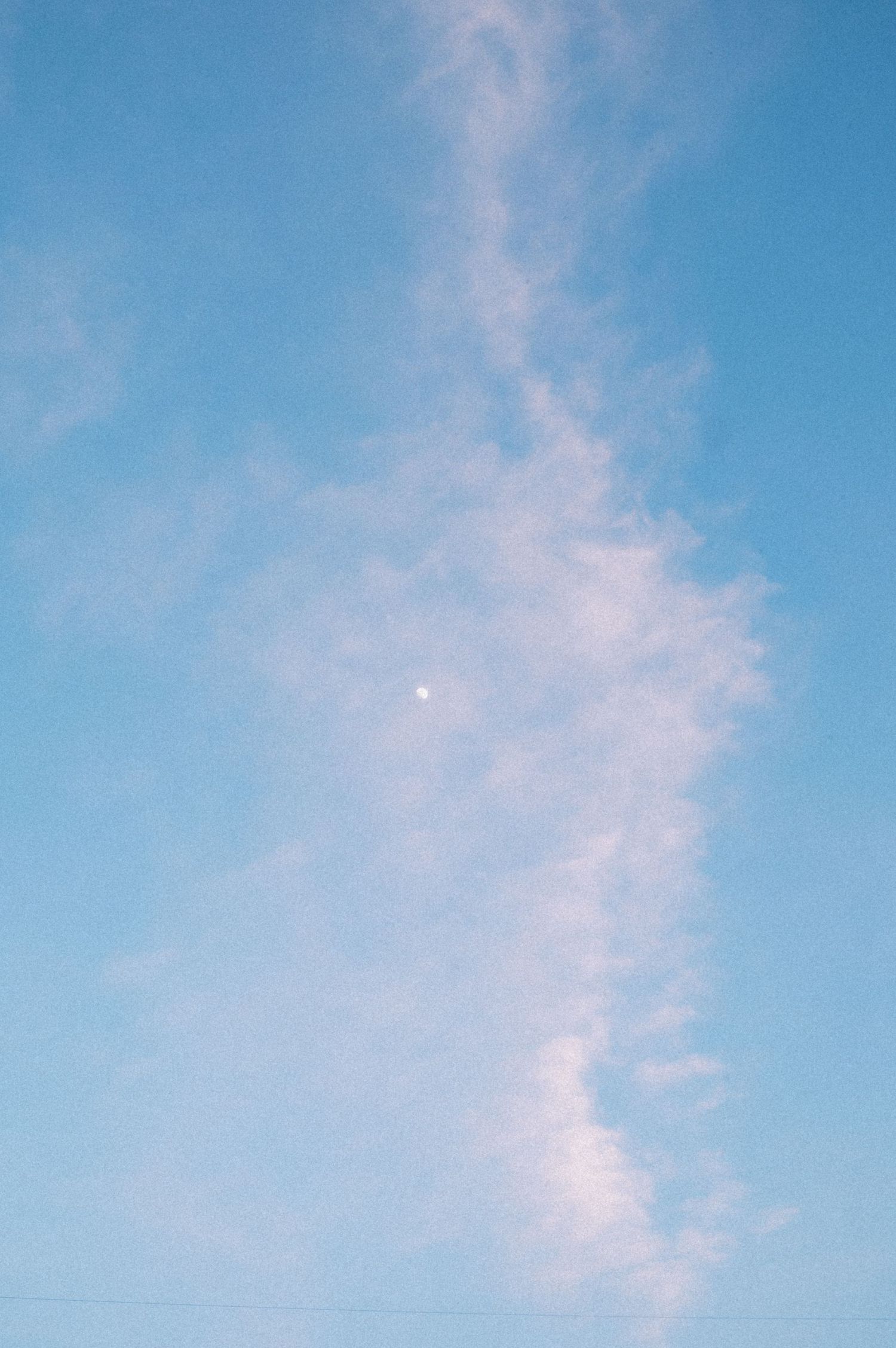 Wispy clouds streak across a bright blue summer sky.