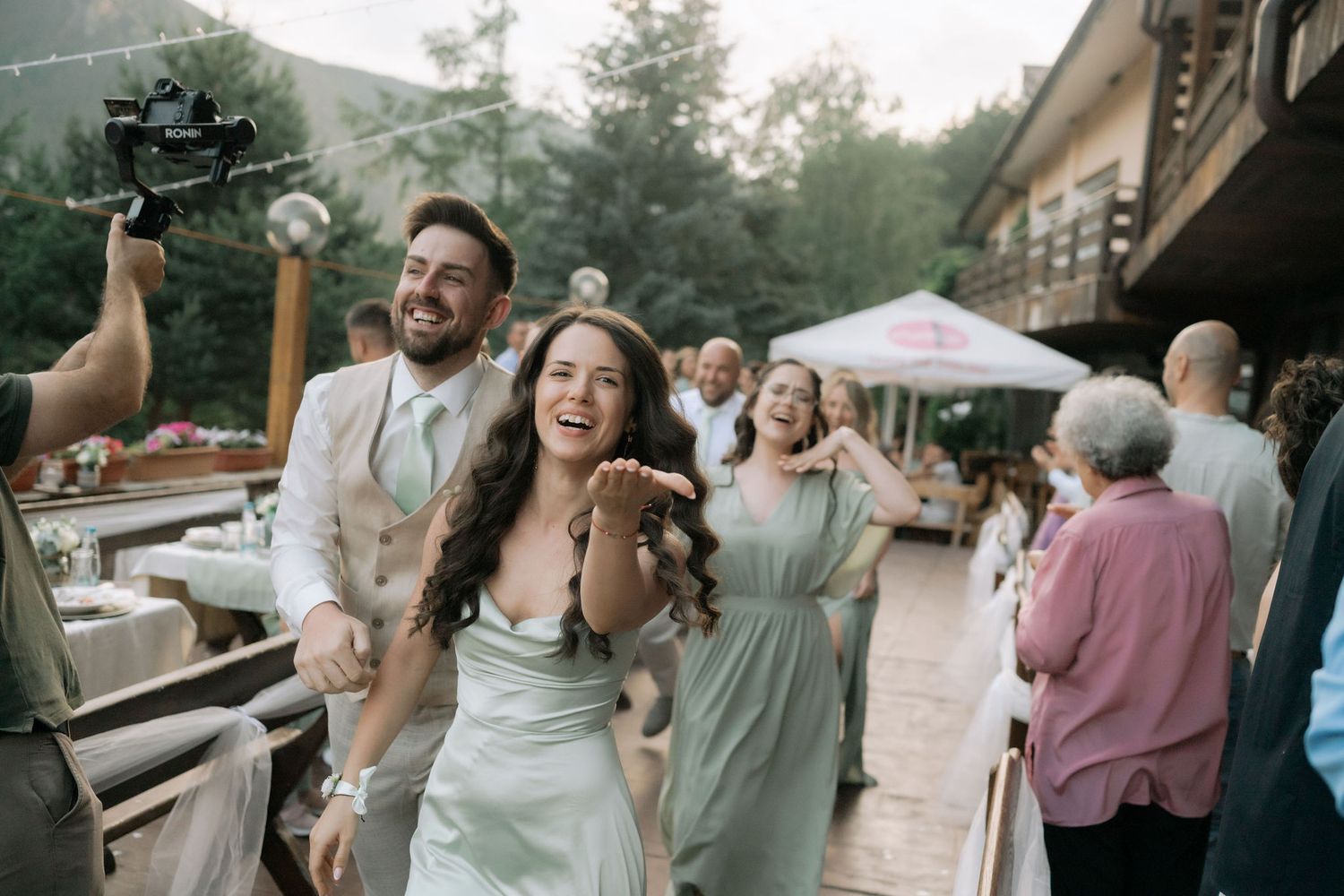 Wedding guests dance and celebrate together during an outdoor evening reception at a rustic venue.