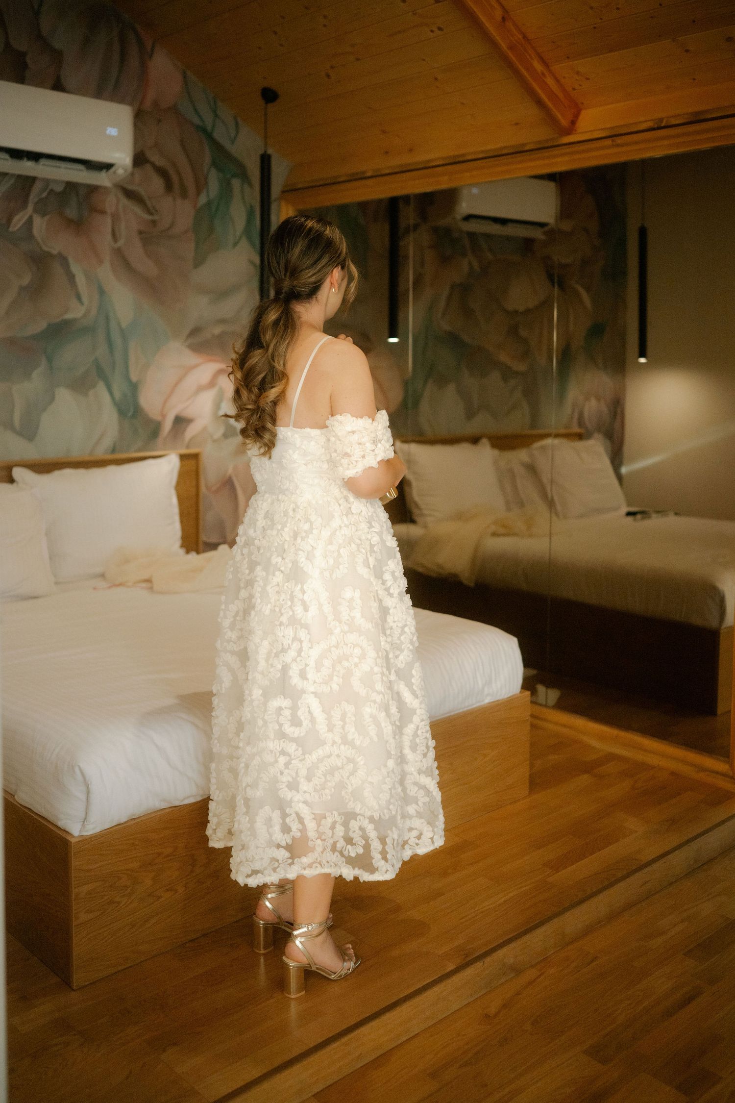 A person in a white lace dress walks across a wooden floor in a dimly lit room with multiple sequential views.
