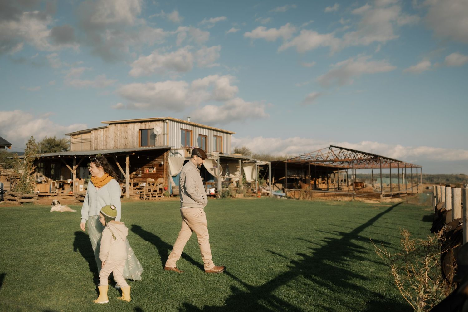 Wedding ceremony setup in a desert landscape with wooden benches and natural decor against a blue sky.