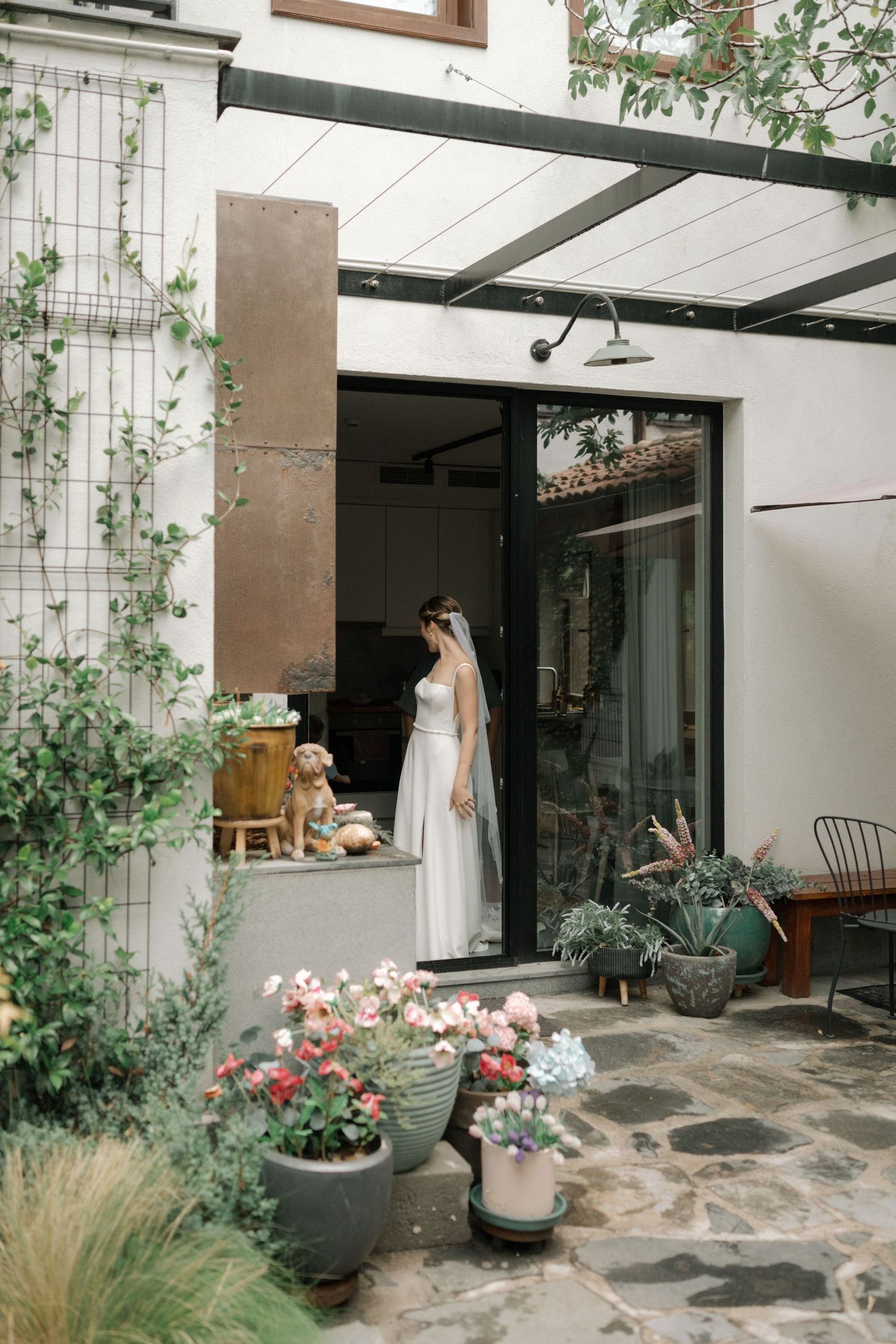 A series of outdoor courtyard views showing stone pathways, potted plants, and modern architectural elements.