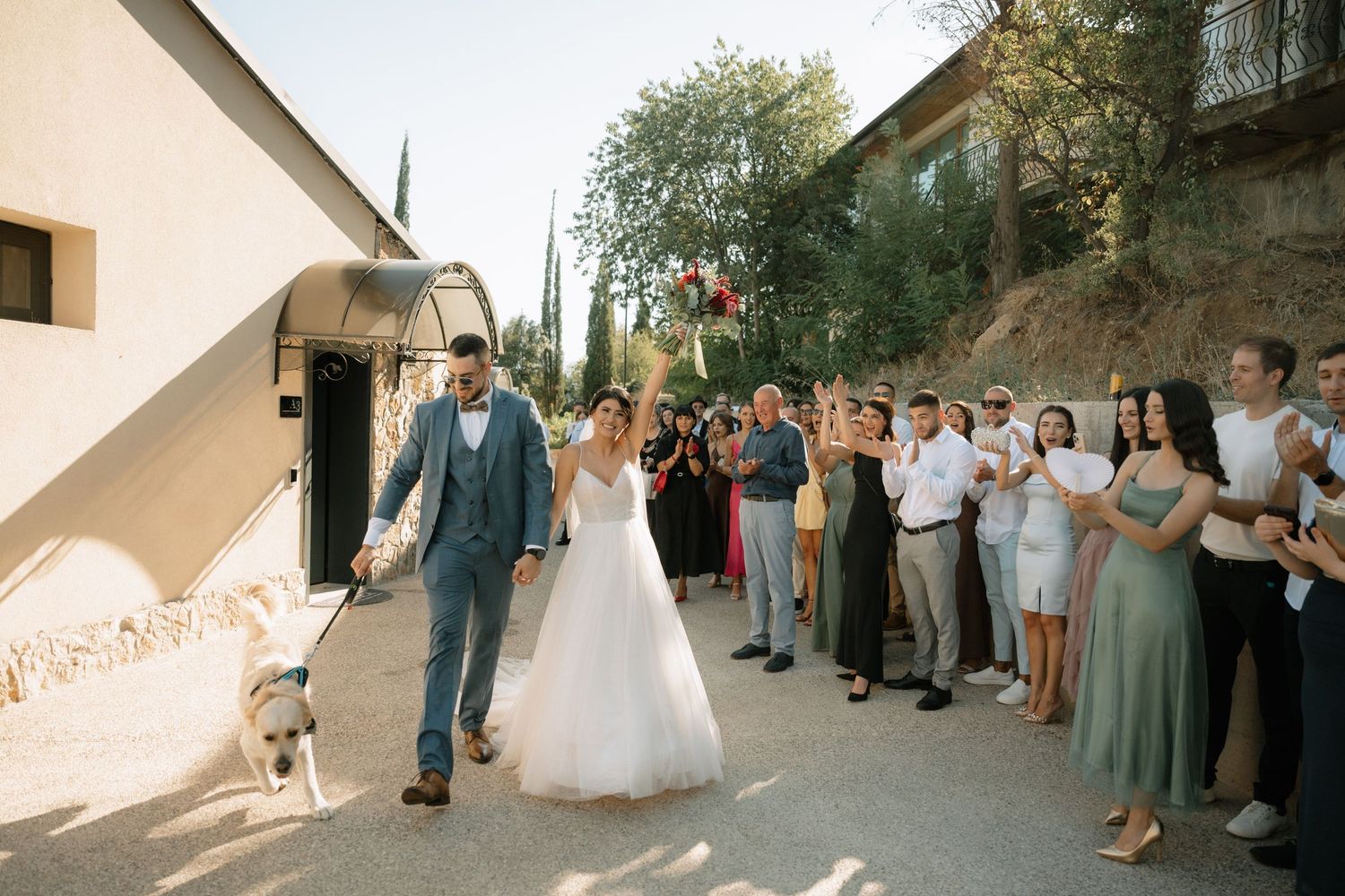 A romantic outdoor wedding ceremony with guests watching the couple dance together in a beautiful garden setting.