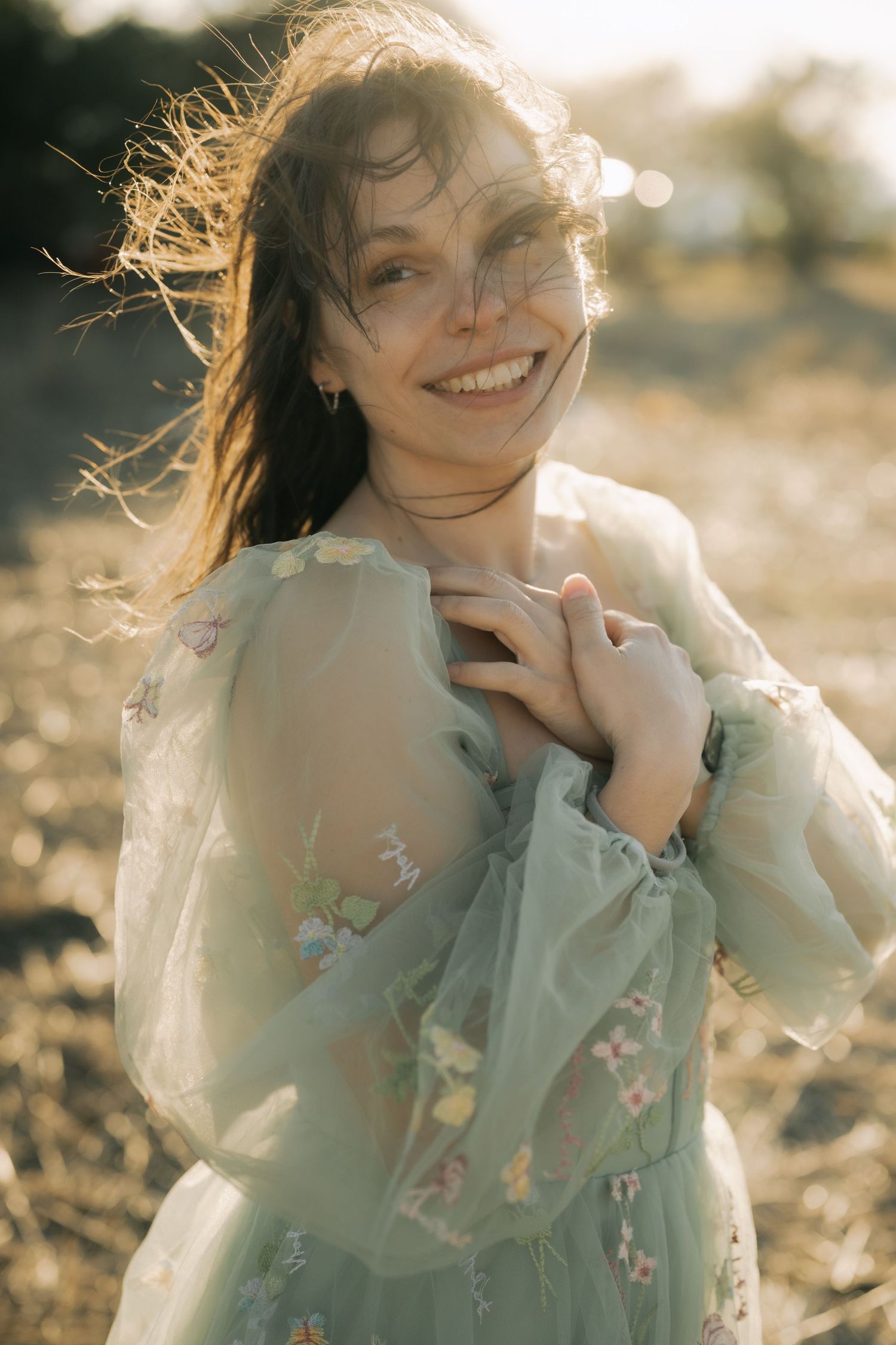 A dreamy portrait series of someone in a mint green floral dress with windswept hair during golden hour.