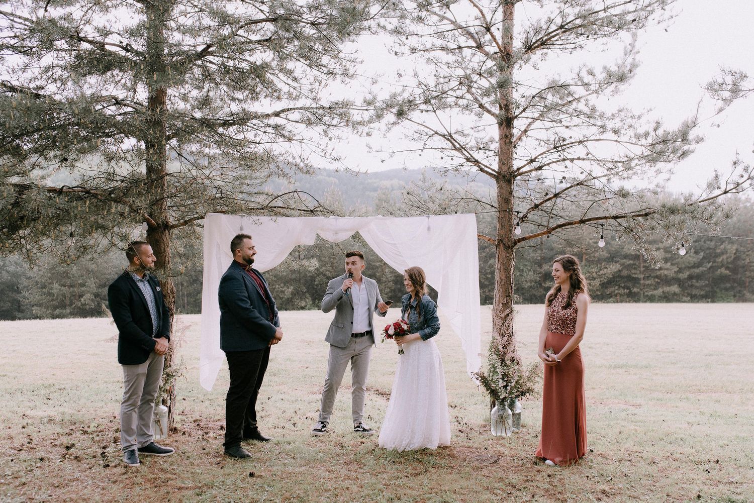 Wedding ceremony setup in a rustic outdoor setting with pine trees and natural scenery.