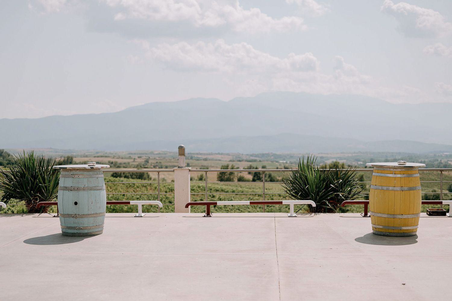 Panoramic view of a mountain landscape with scattered barrels in the distance.