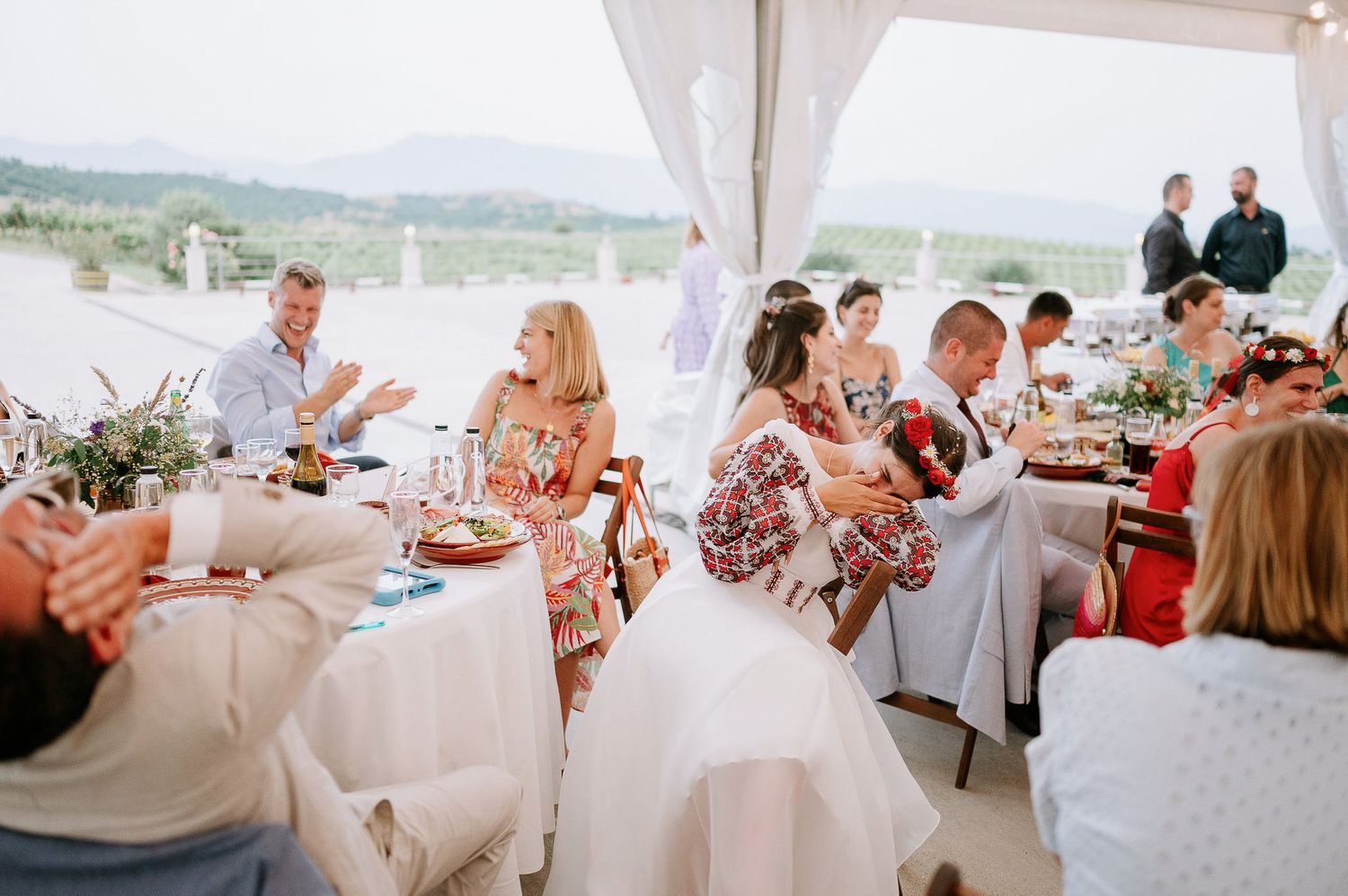 Elegant wedding reception under white tent with panoramic views of rolling hills.