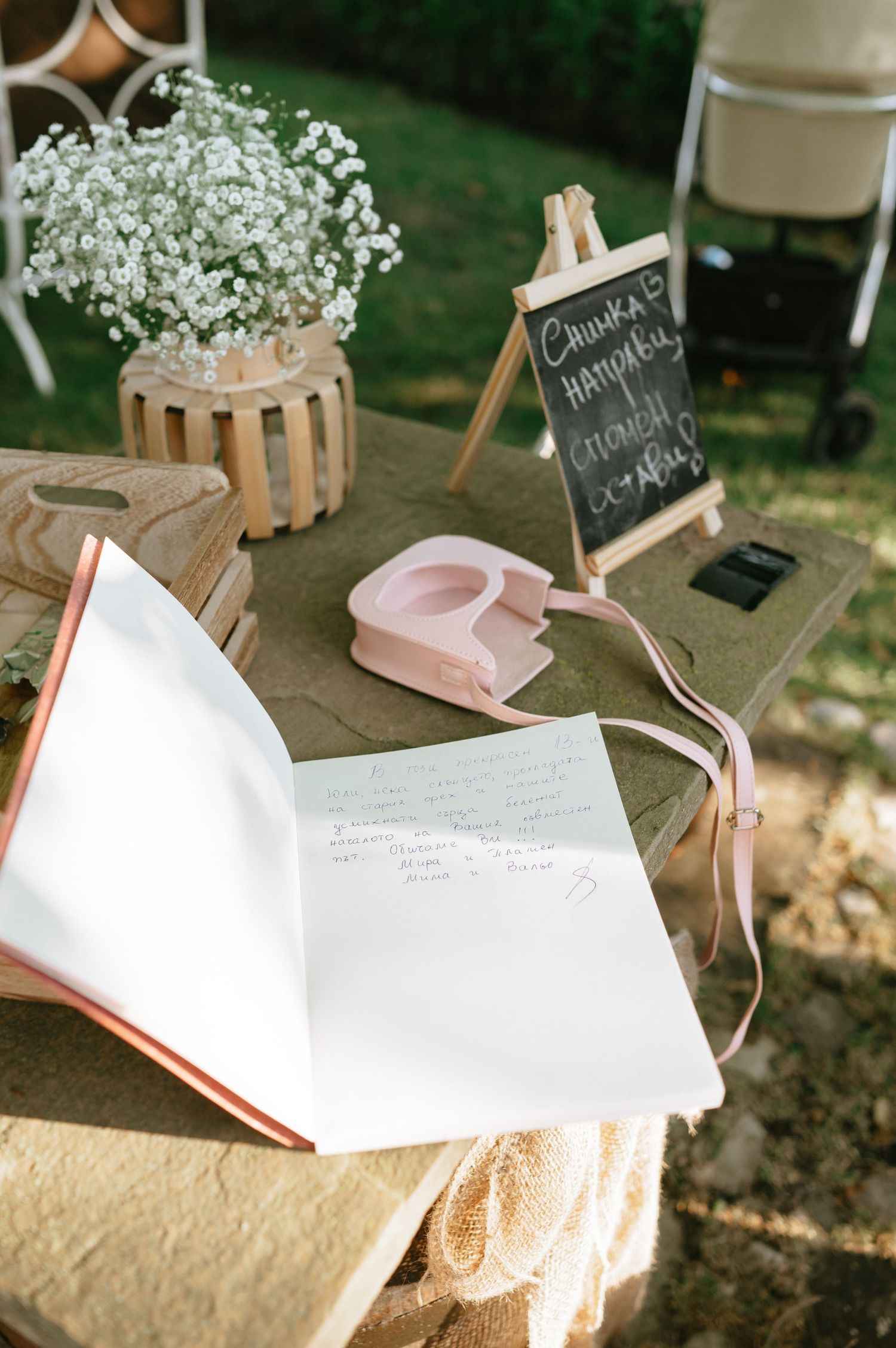 Wedding guest book and decorative elements with baby's breath flowers on rustic wooden table.