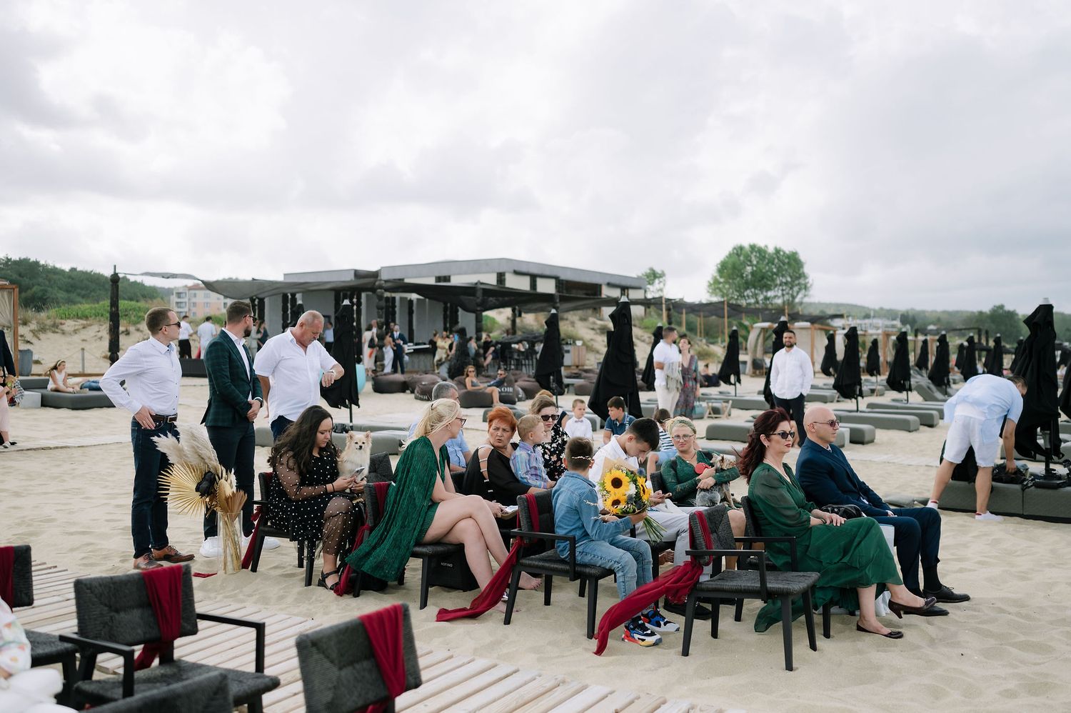 Outdoor event setup with guests seated at tables on a paved terrace.