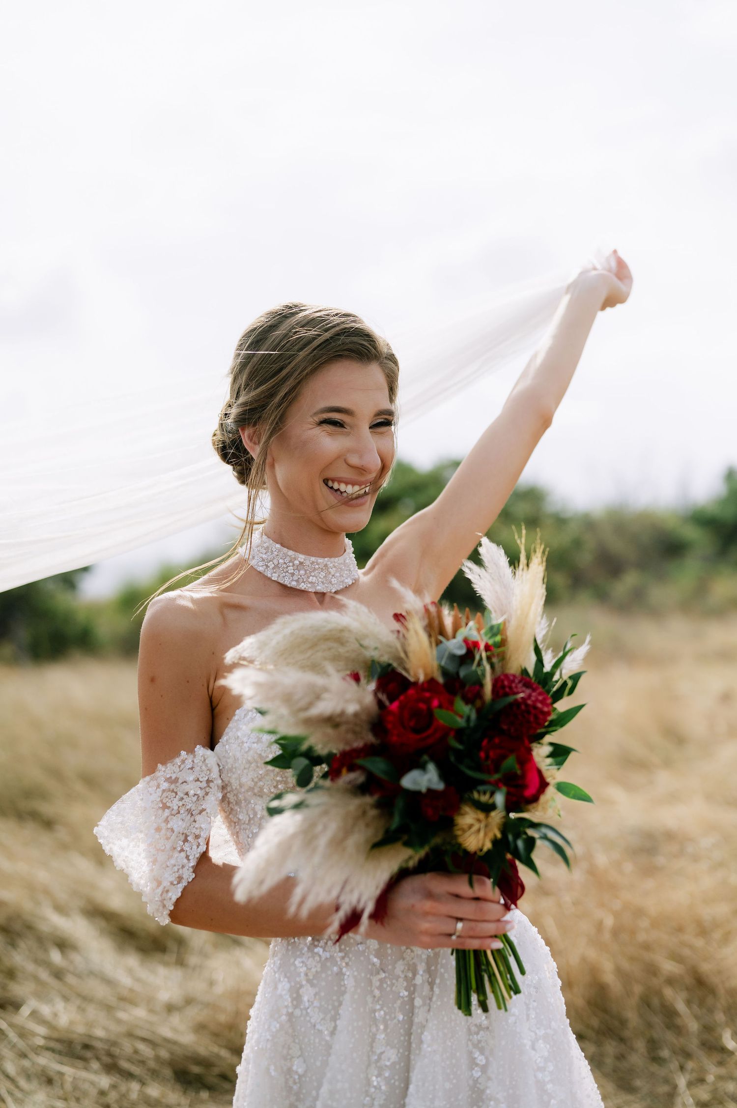 Joyful bride spinning in a white ballgown with her veil flowing in the wind.