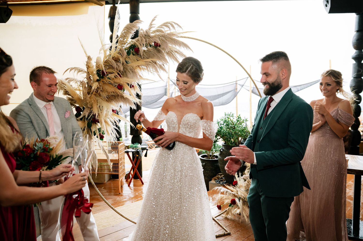 Wedding celebration in a rustic venue with wooden ceiling beams and elegant dried floral arrangements.