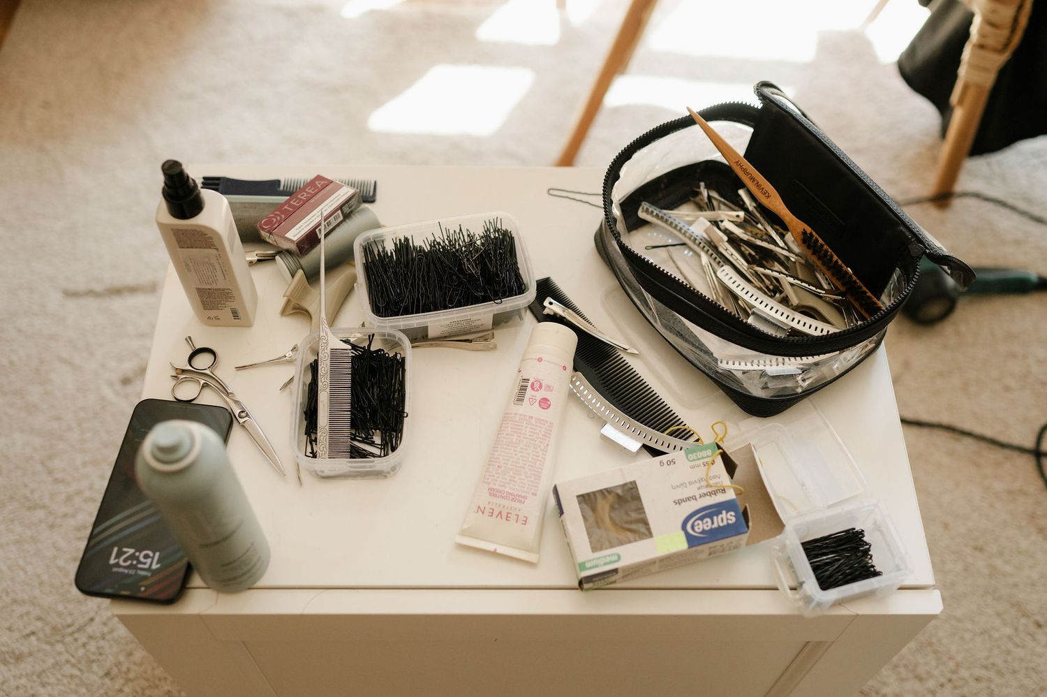 Professional makeup and beauty supplies arranged on white surface with brushes and products.