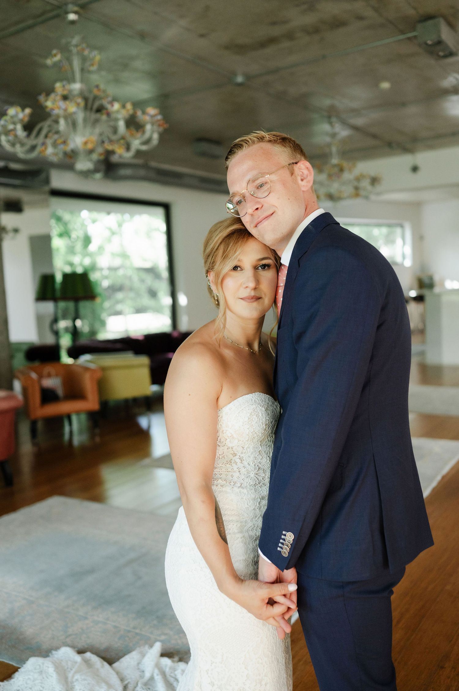 A romantic moment between newlyweds in an elegant venue with natural lighting.