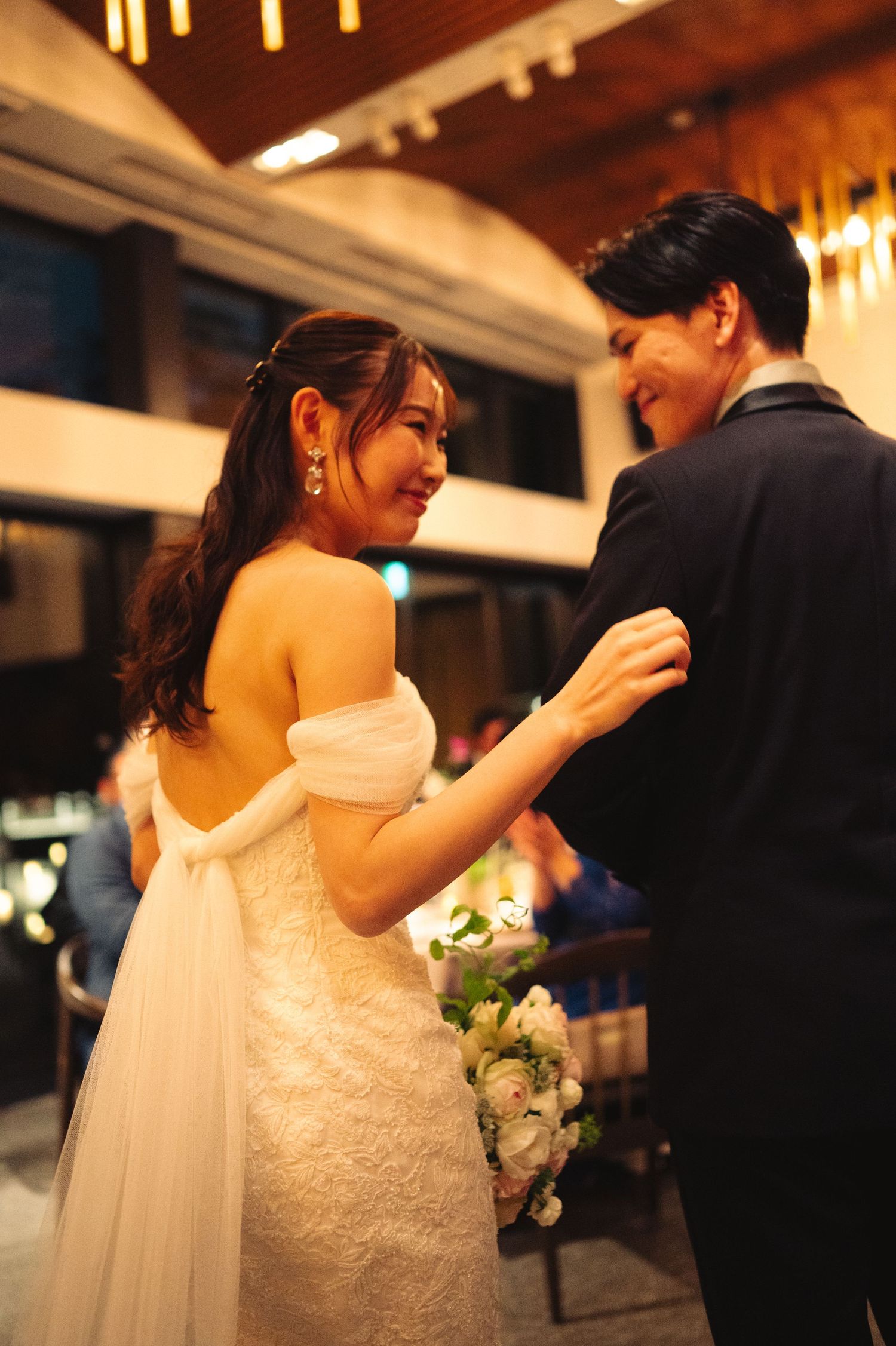 Romantic wedding reception moments with bride in lace dress and groom in classic tuxedo.
