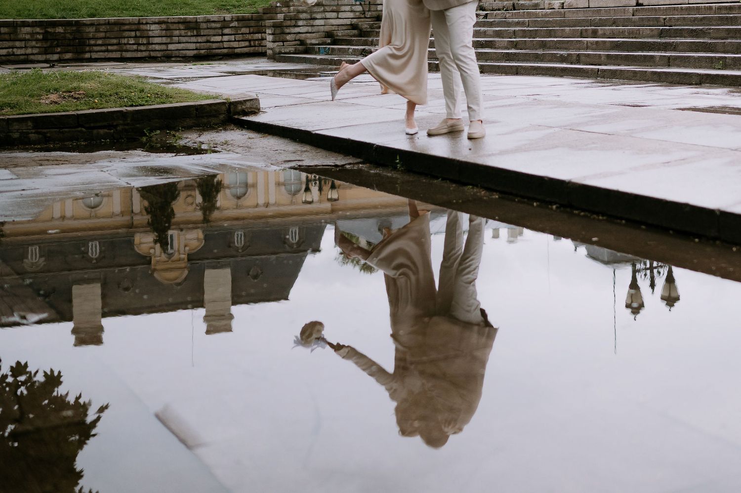 Dance performance creates mirror image in reflecting pool with historic building backdrop.