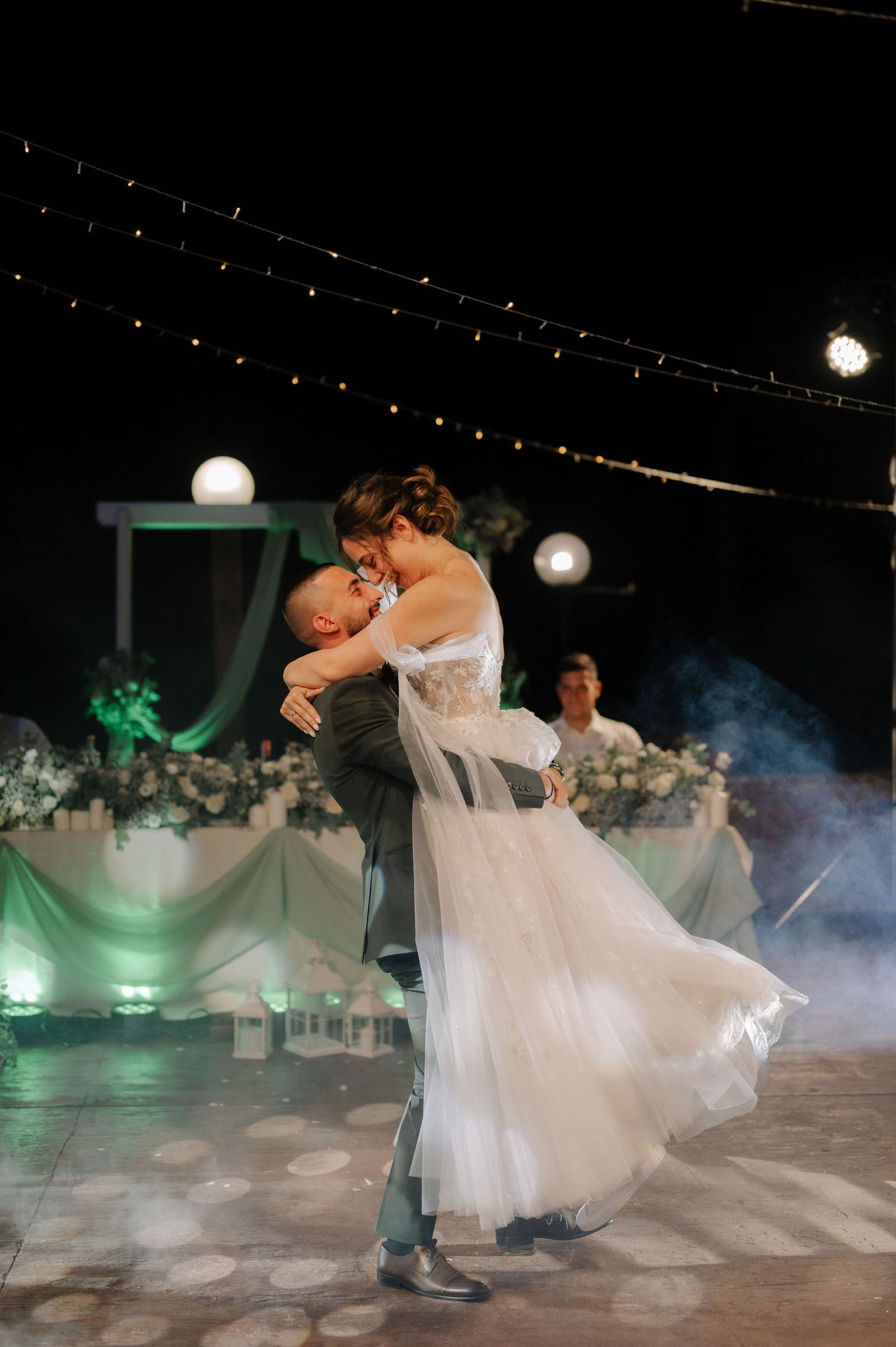 A romantic first dance at a wedding reception with fog effects on the dance floor creates a dreamy atmosphere.