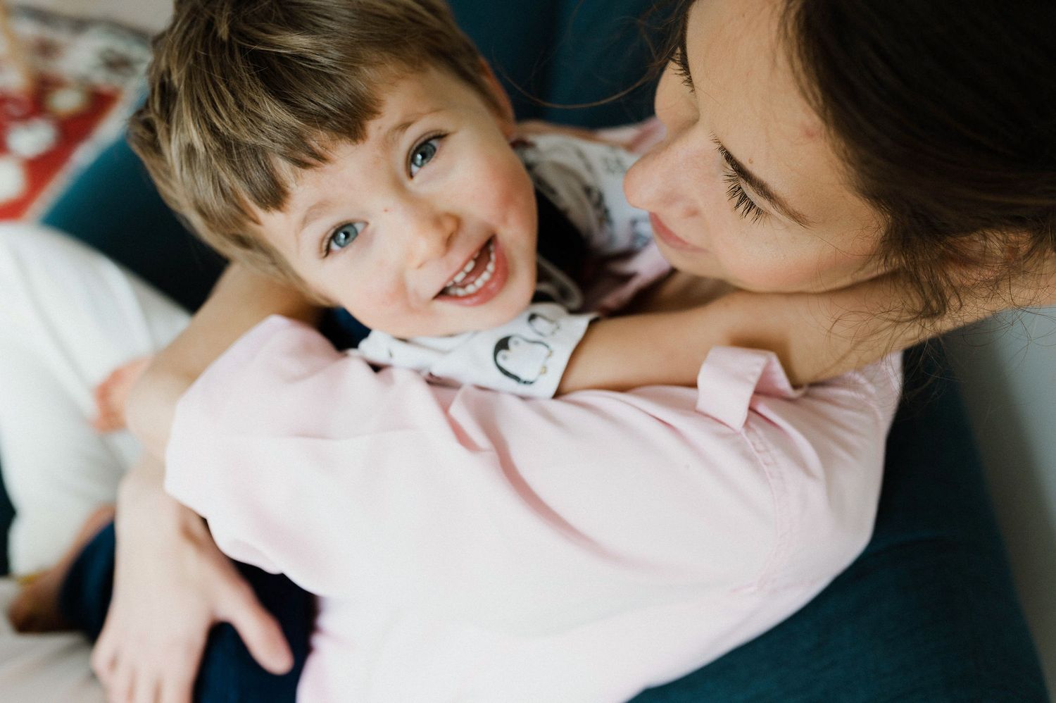 A tender moment between a parent and child cuddling together, sharing warmth and affection in soft lighting.
