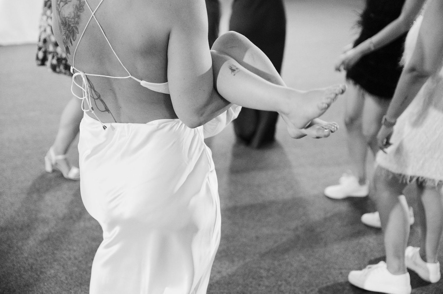 A black and white photo shows a couple dancing together at what appears to be a wedding reception.