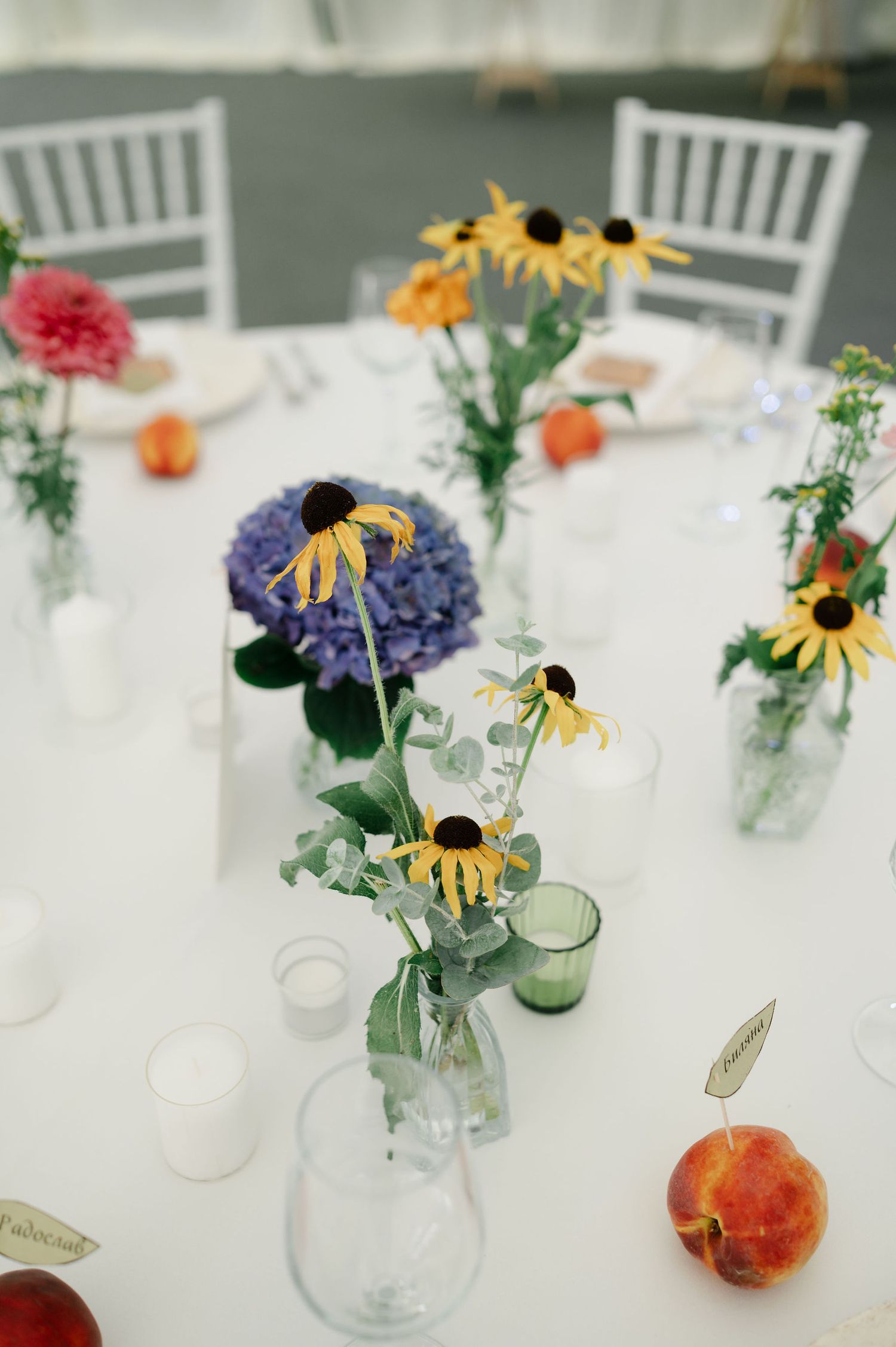 Elegant table settings with sunflowers, hydrangeas and peaches as natural decor elements.