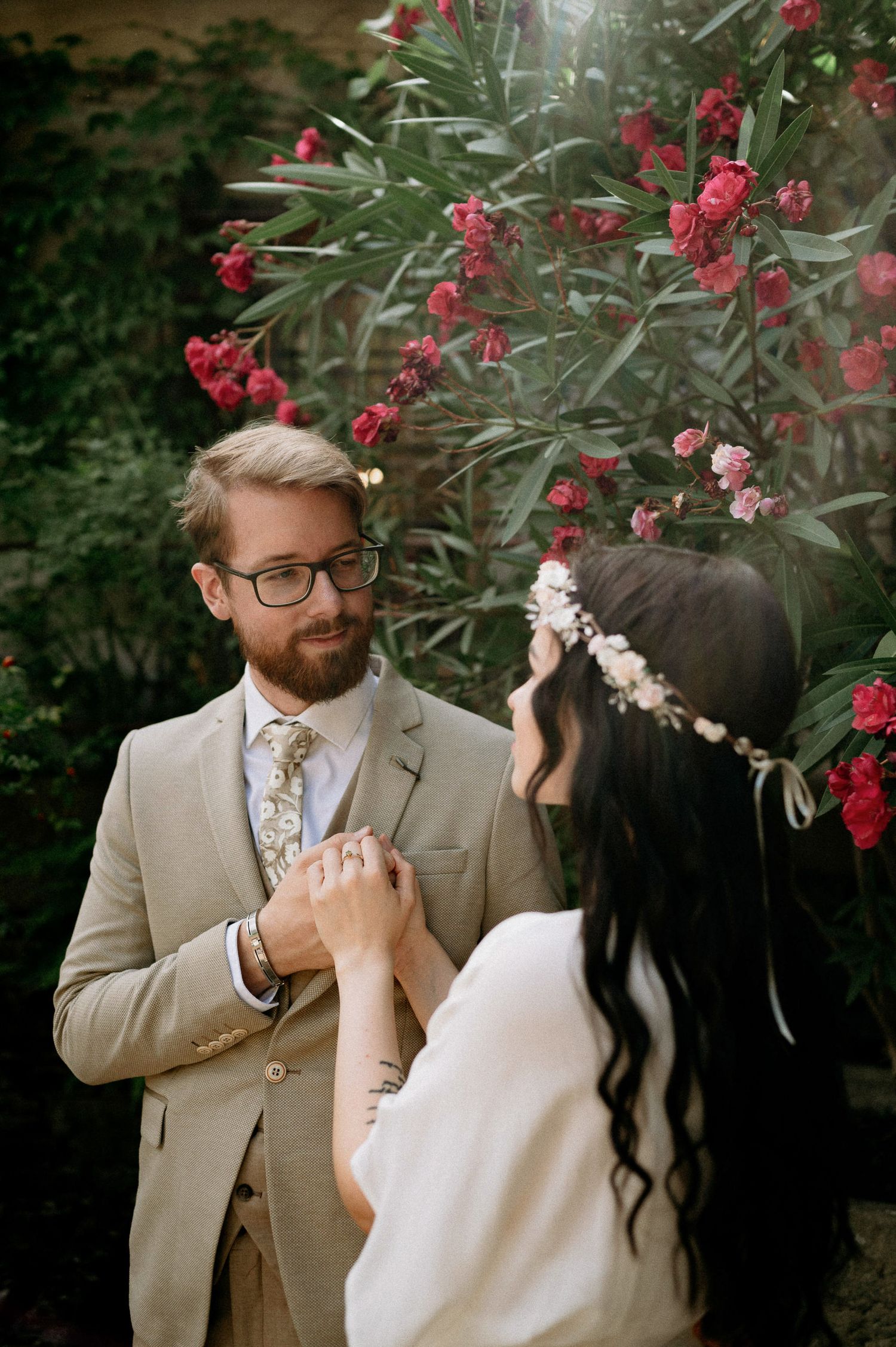 Romantic garden photoshoot with red flowers and natural greenery in the background.