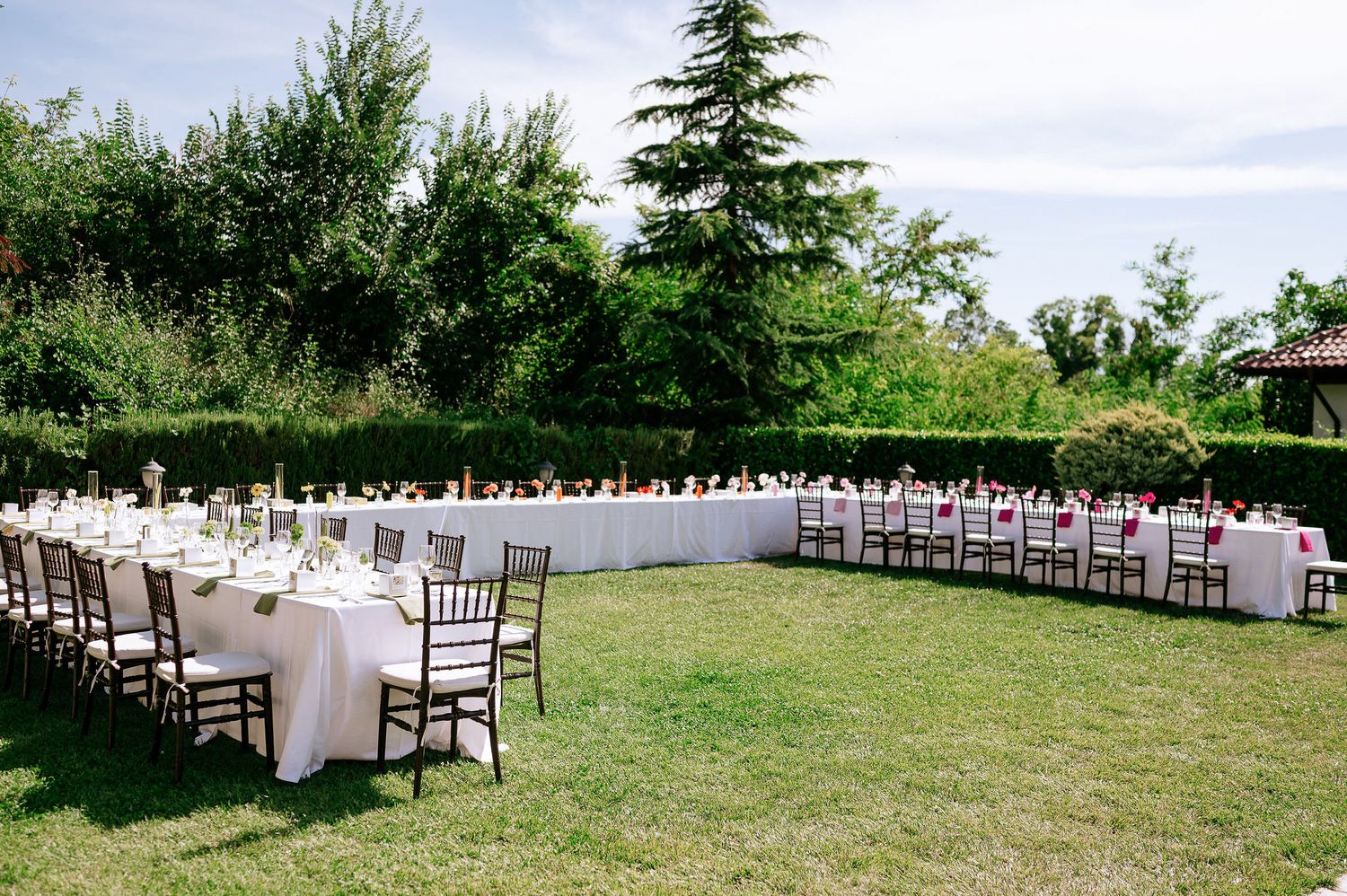 Aerial view of outdoor wedding reception tables arranged in long rows on a grassy lawn.
